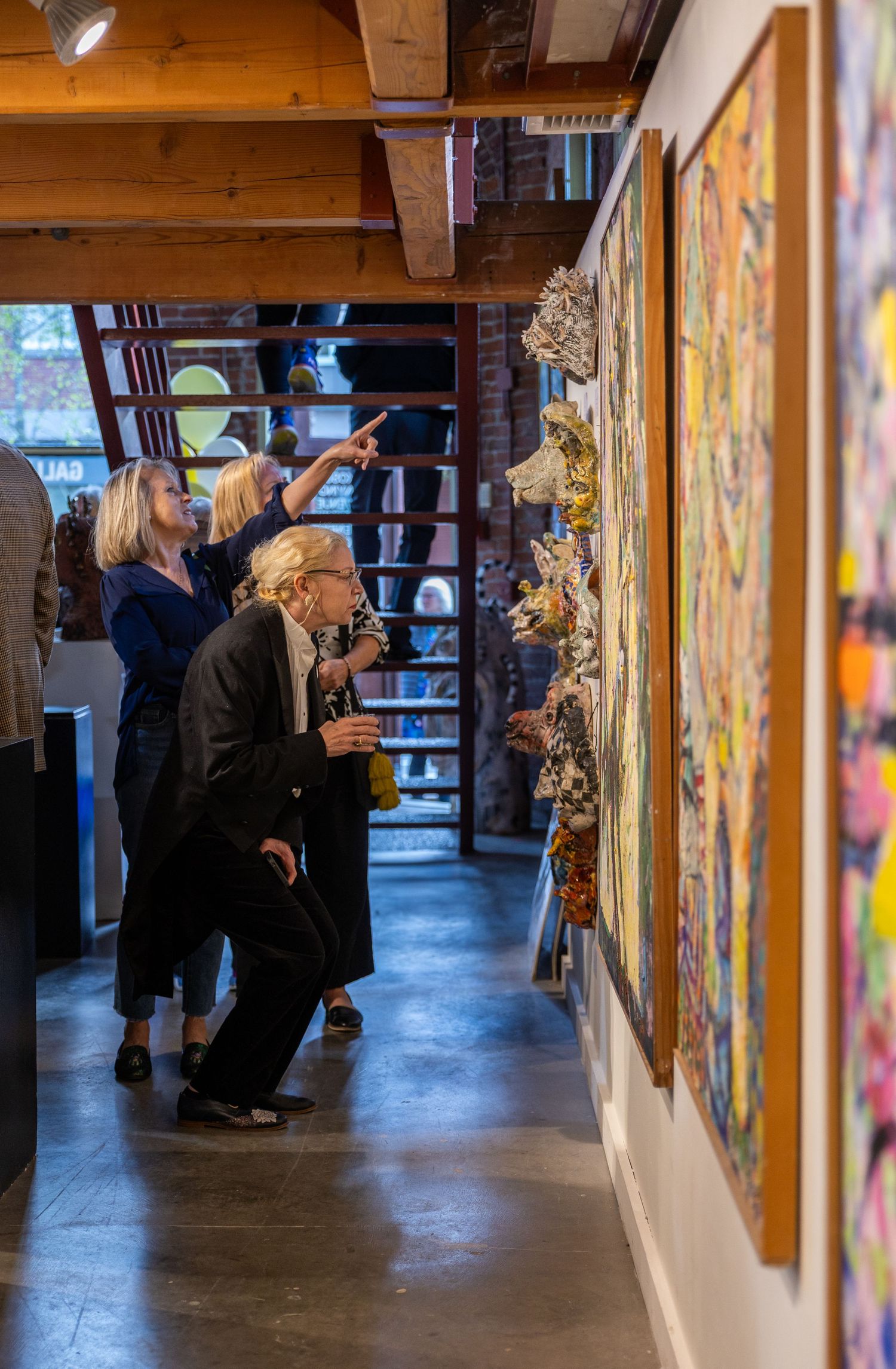 Attendees enjoying sculptures at an art gallery opening in Kirkland.
