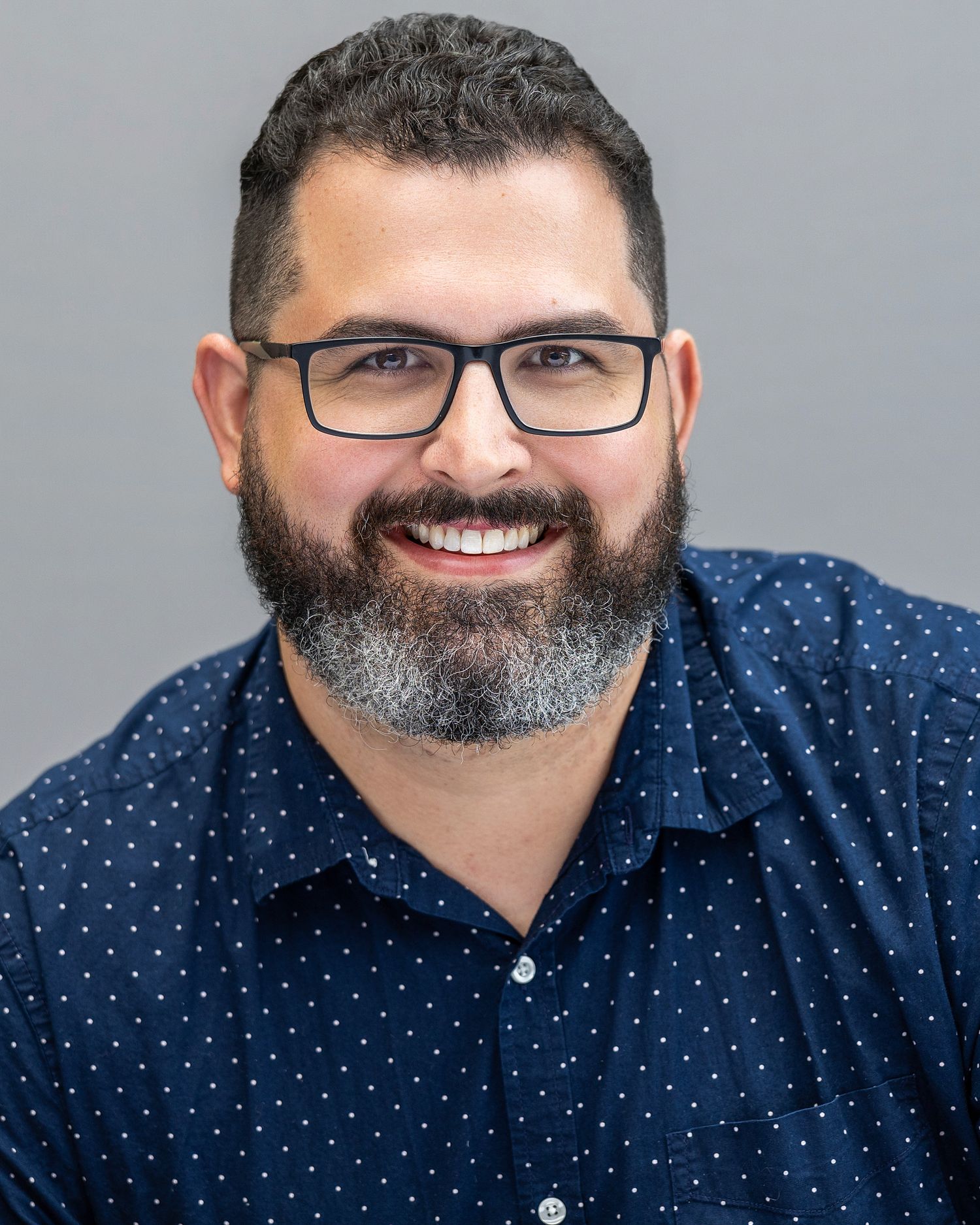 Confident business professional photographed against a neutral studio background