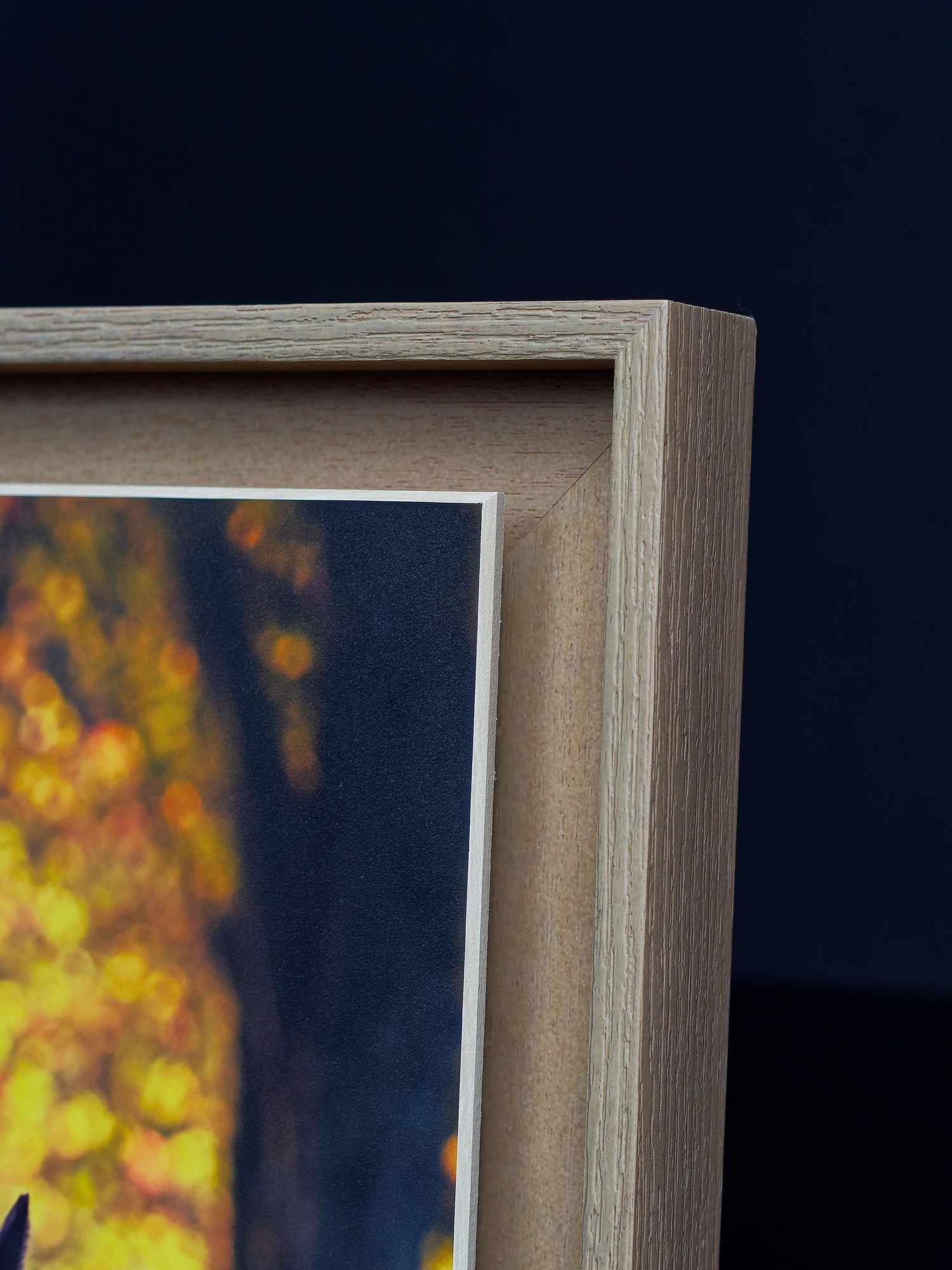 Sequence of abstract art frames showing yellow and orange bokeh effects against a dark background with wooden frames.