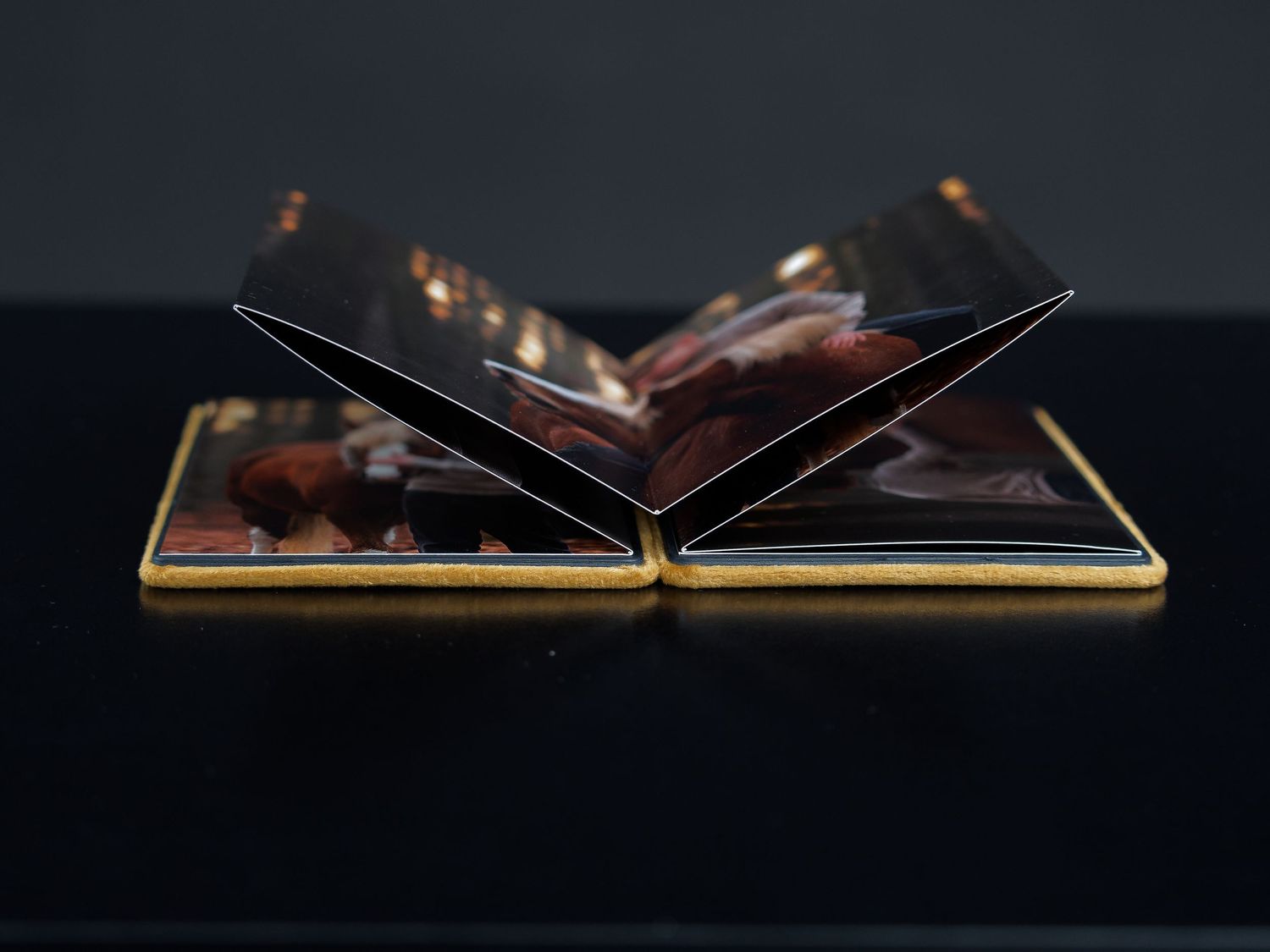 Open photo album with black pages displayed on dark surface.