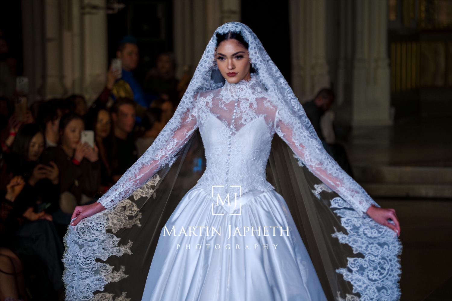 Models showcase elegant wedding gowns on a runway during a bridal fashion show.