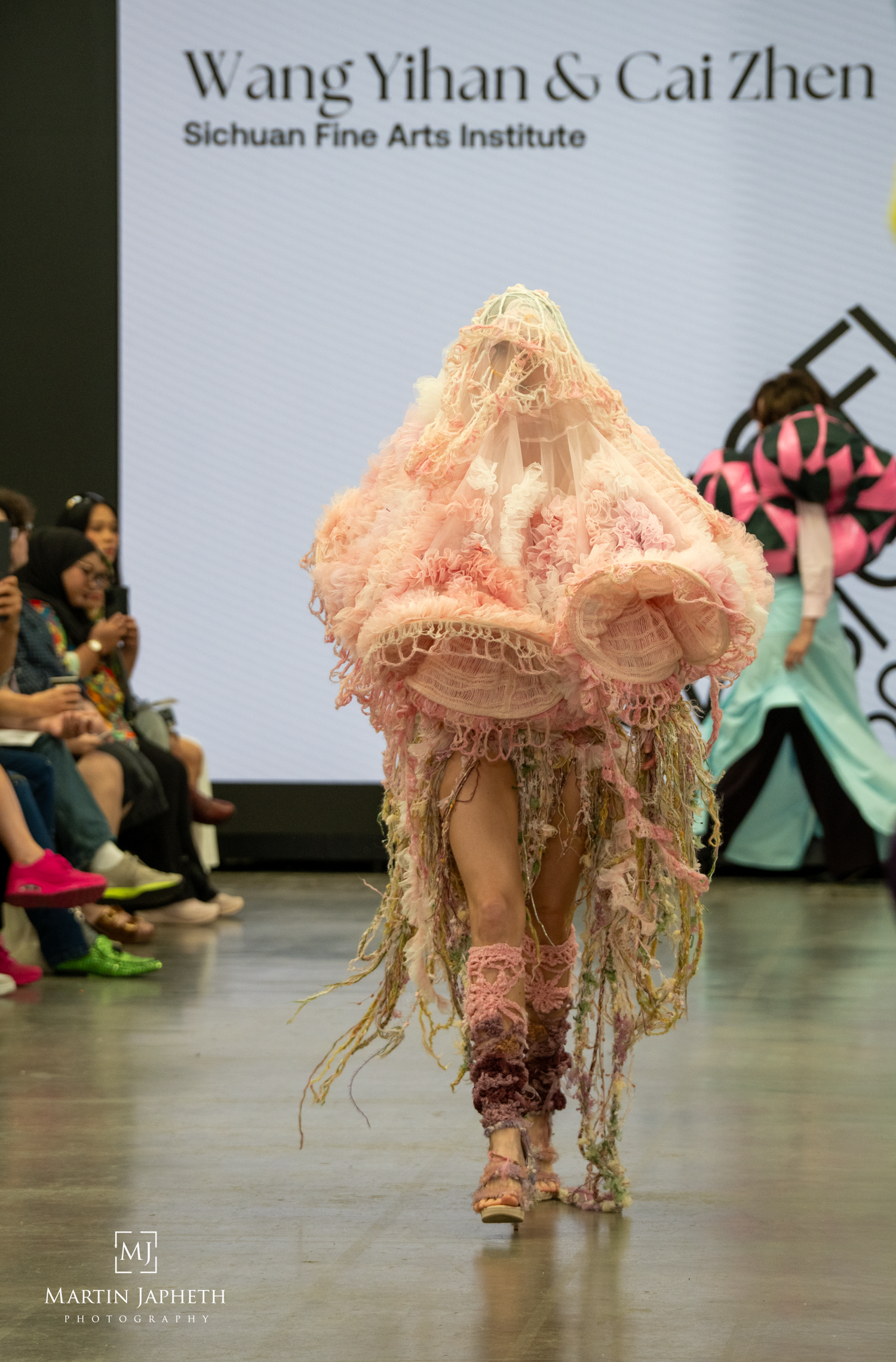 A model walks the runway in an avant-garde pink sculptural gown by Wang Yihan & Cai Zhen at Sichuan Fine Arts Institute. Martin Japheth