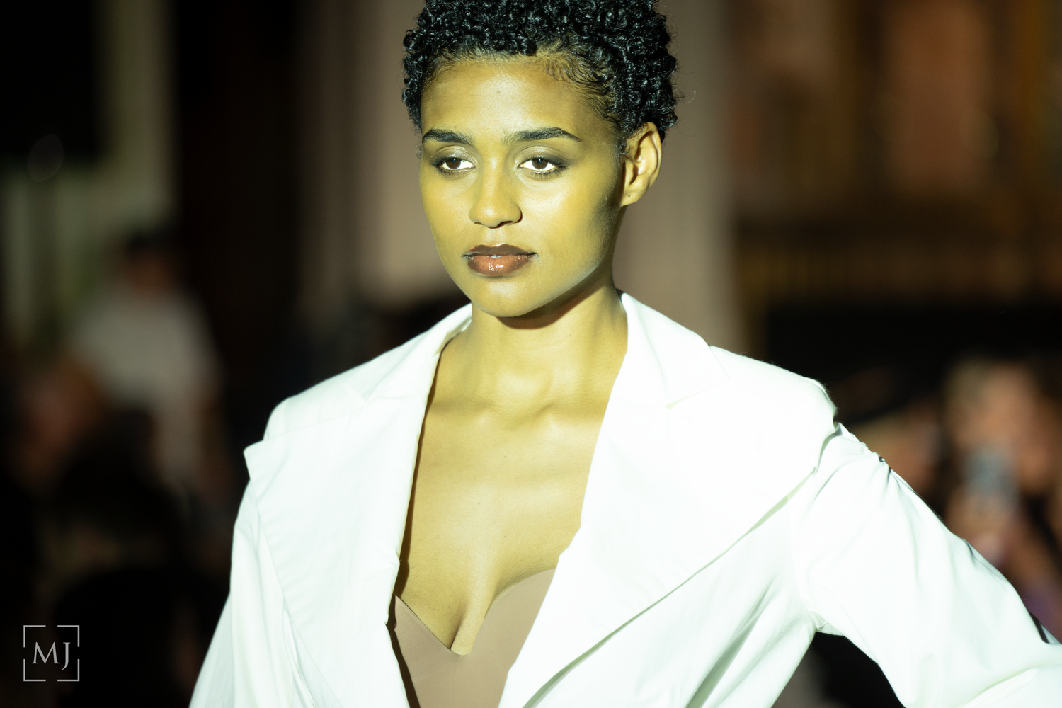 Models showcase elegant white evening wear collection on fashion runway during haute couture show.