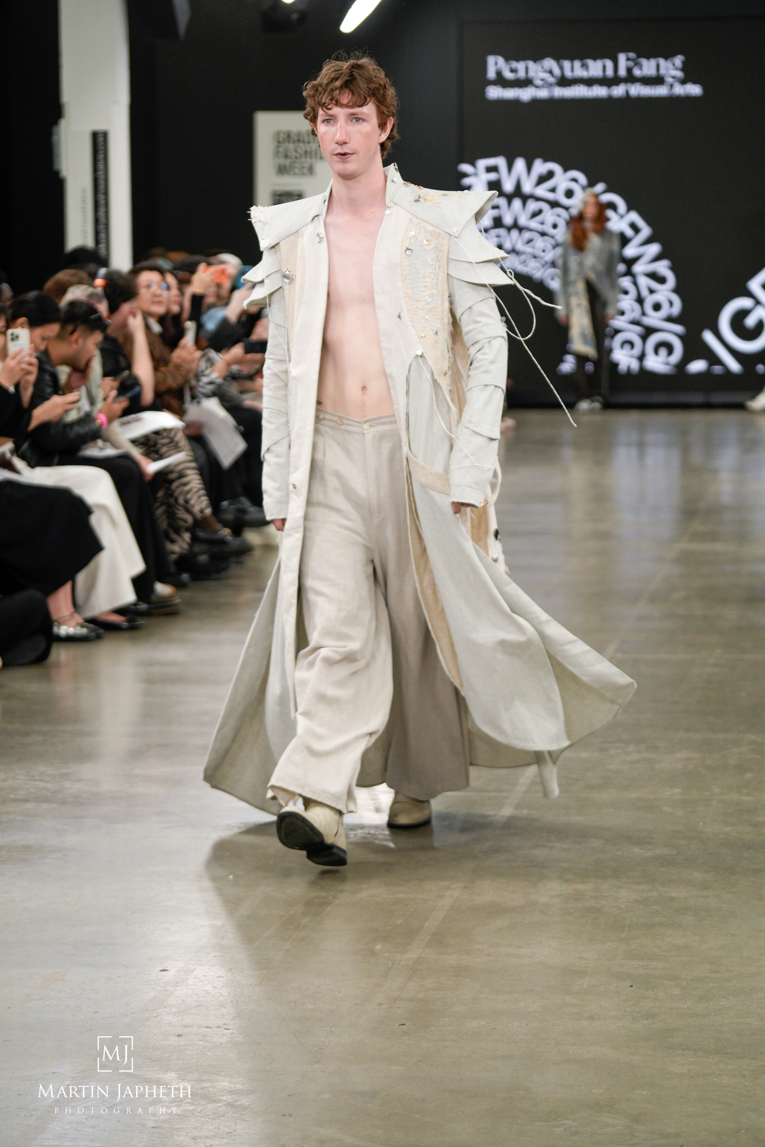 Male model walks runway in cream trench coat and wide-leg trousers at Pengyuan Fang Shanghai Institute of Visual Arts fashion show.