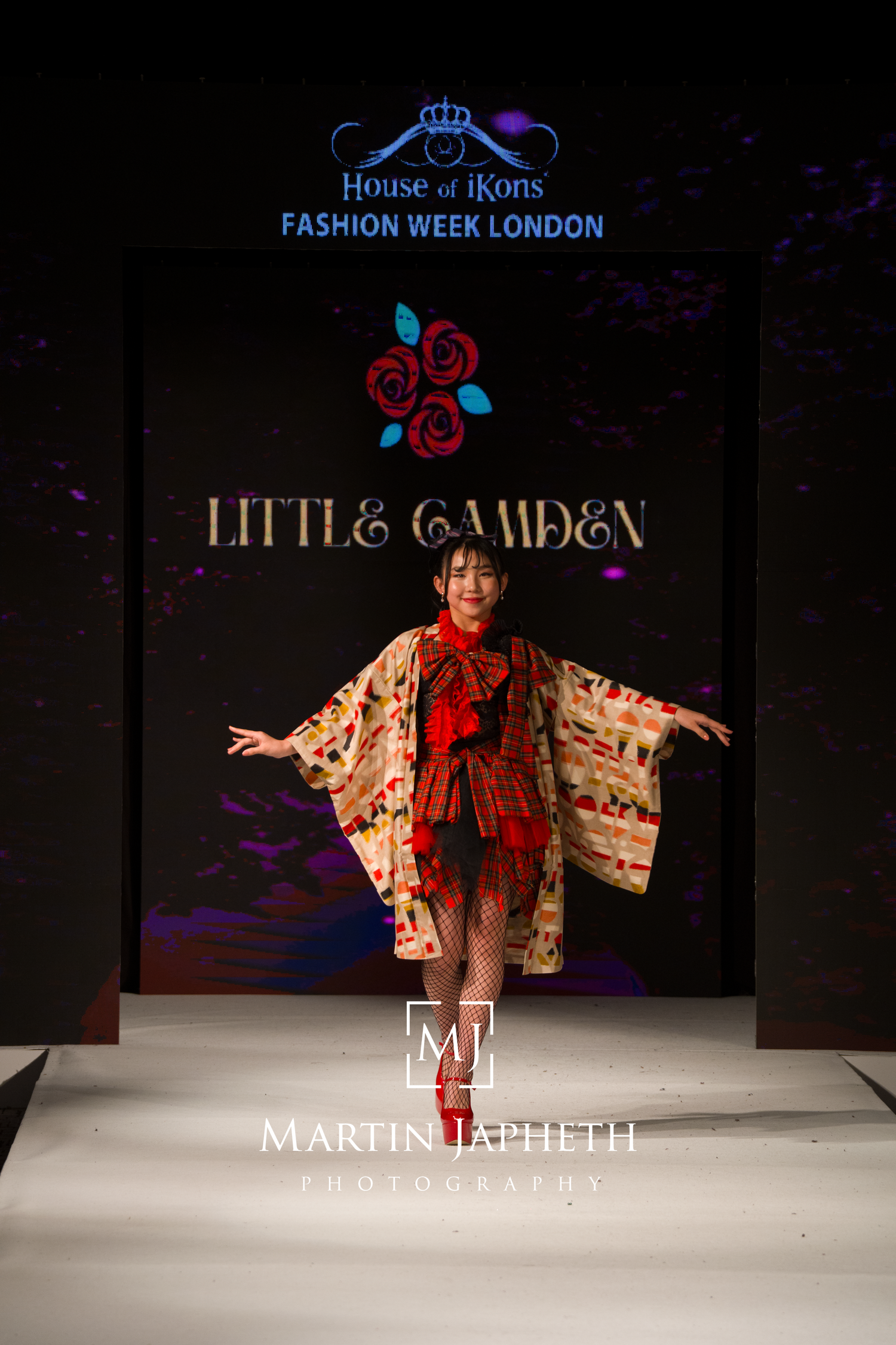 A model walks the runway in a floral kimono-style garment at House of iKons Fashion Week London show.