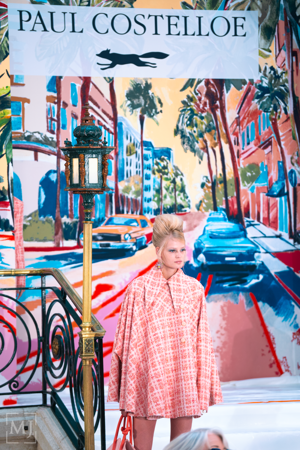 Vibrant street art mural depicting colorful urban scenes with buildings, palm trees, and lamp posts in a dynamic style.
