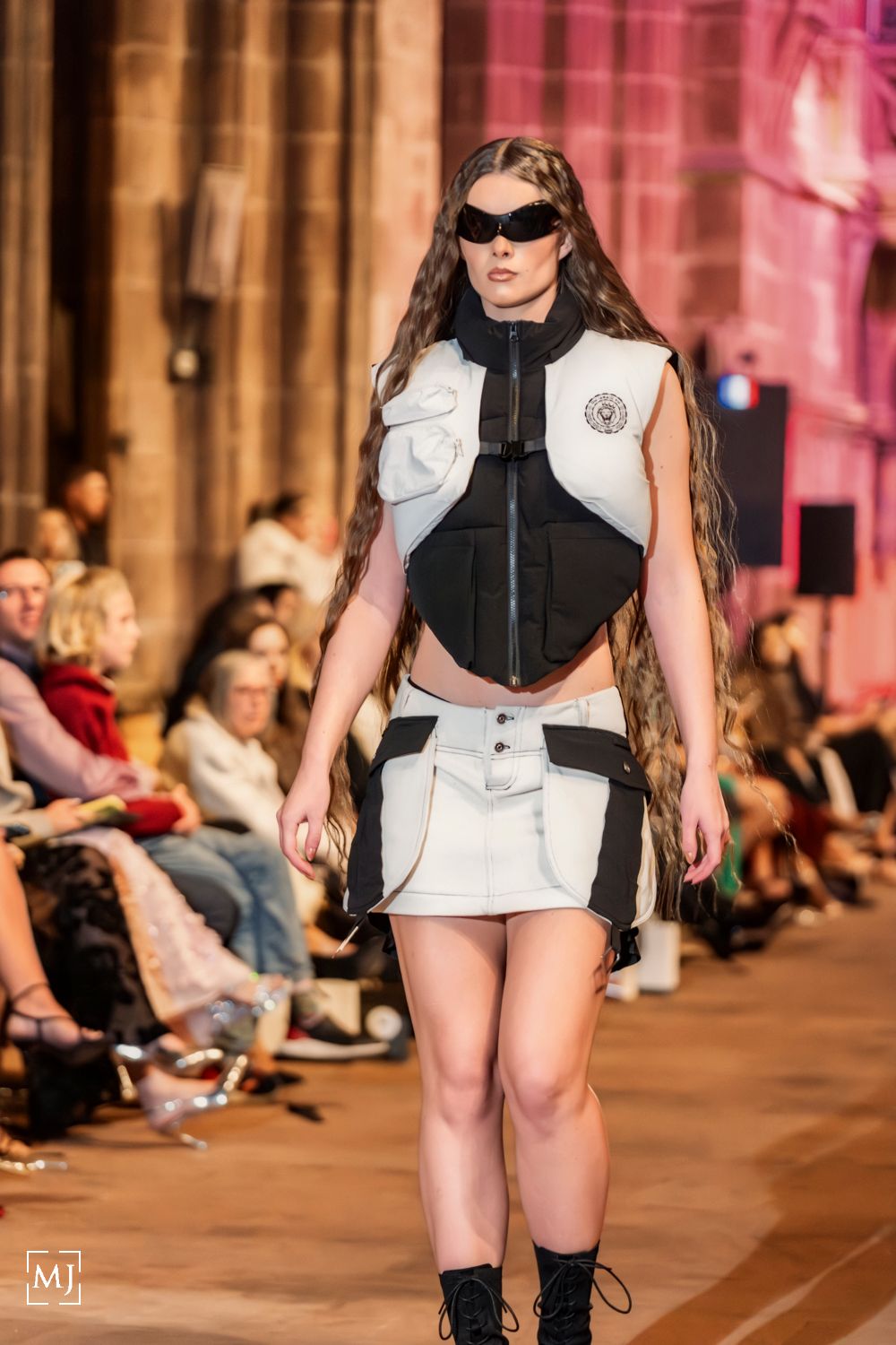 Model walks runway in futuristic black and white outfit with sunglasses during fashion show. Fashion Photographer Martin Japheth