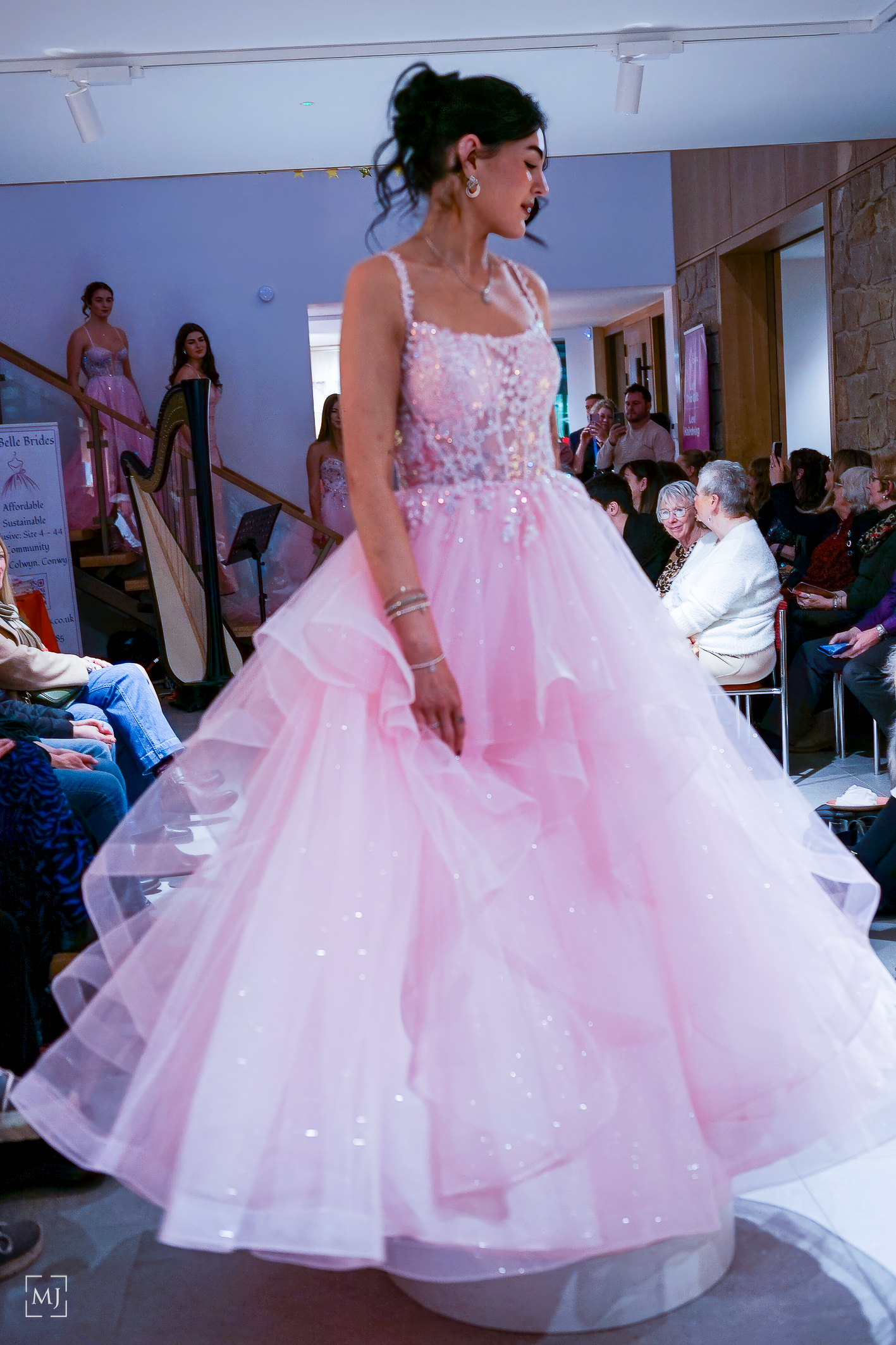 Pink tulle ballgowns with sparkly bodices twirl on display at a formal dress showcase event. Fashion Photographer Martin Japheth