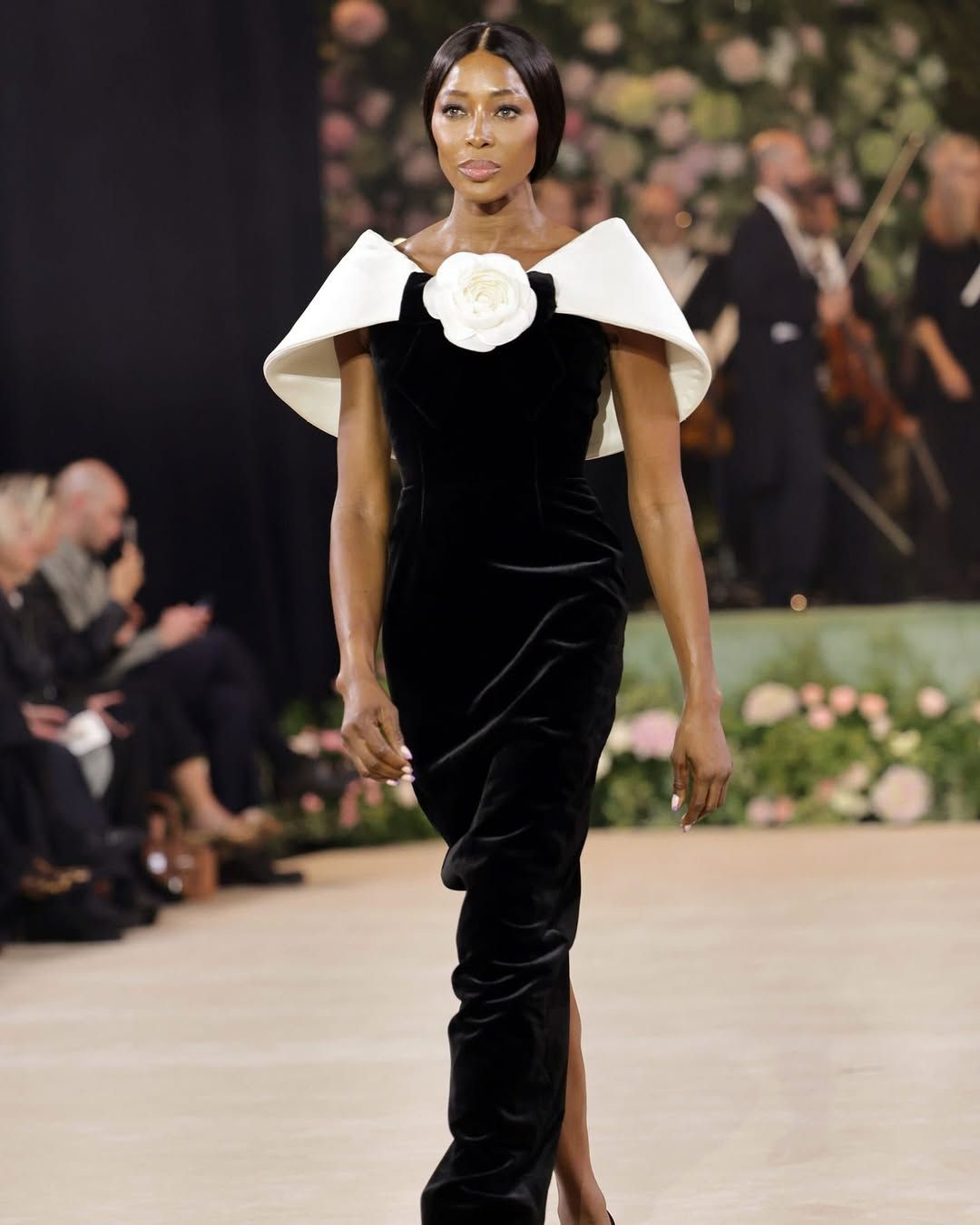 Naomi Campbell walks the runway in a sleek black velvet dress during a high-fashion show presentation. Fashion Photographer Martin Japheth