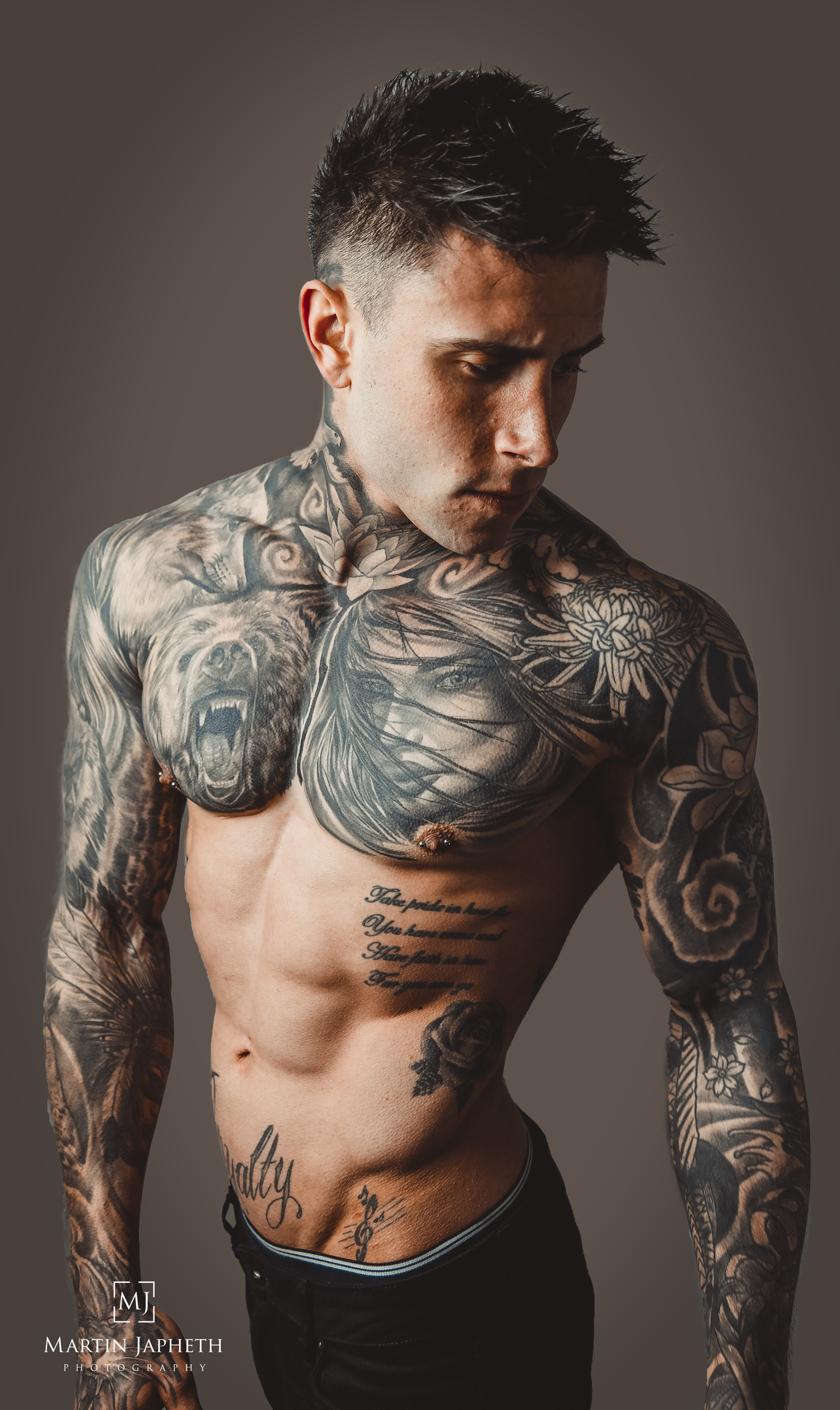 Tattooed shirtless male model with intricate full body tattoos by Martin Japheth Photography.