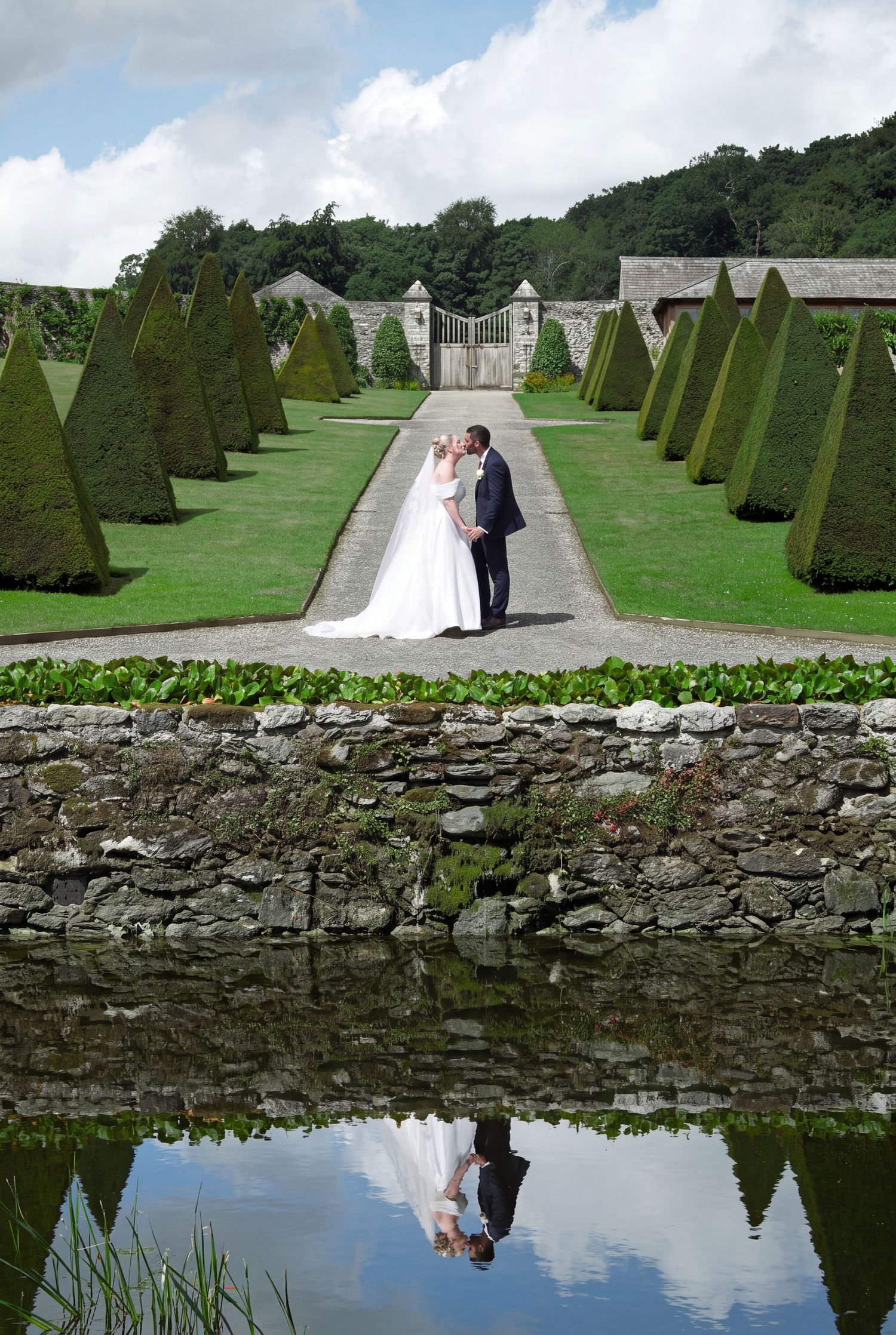 Yasmin & Tom embrace in the walled garden at Plas Cadnant. Wedding shot by Martin Japheth Photography