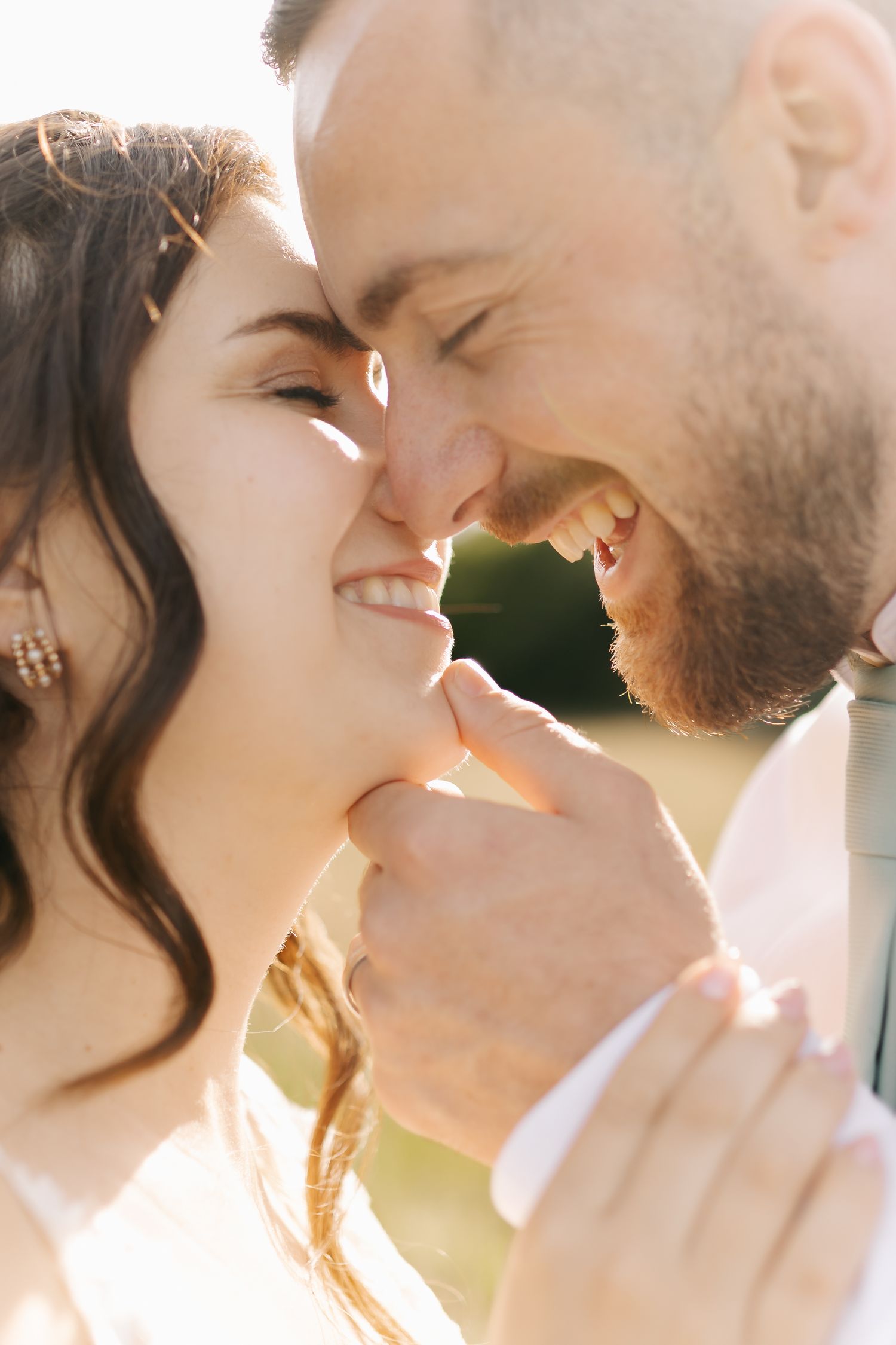 Romantic close-up of couple sharing tender moment in warm sunset light.
