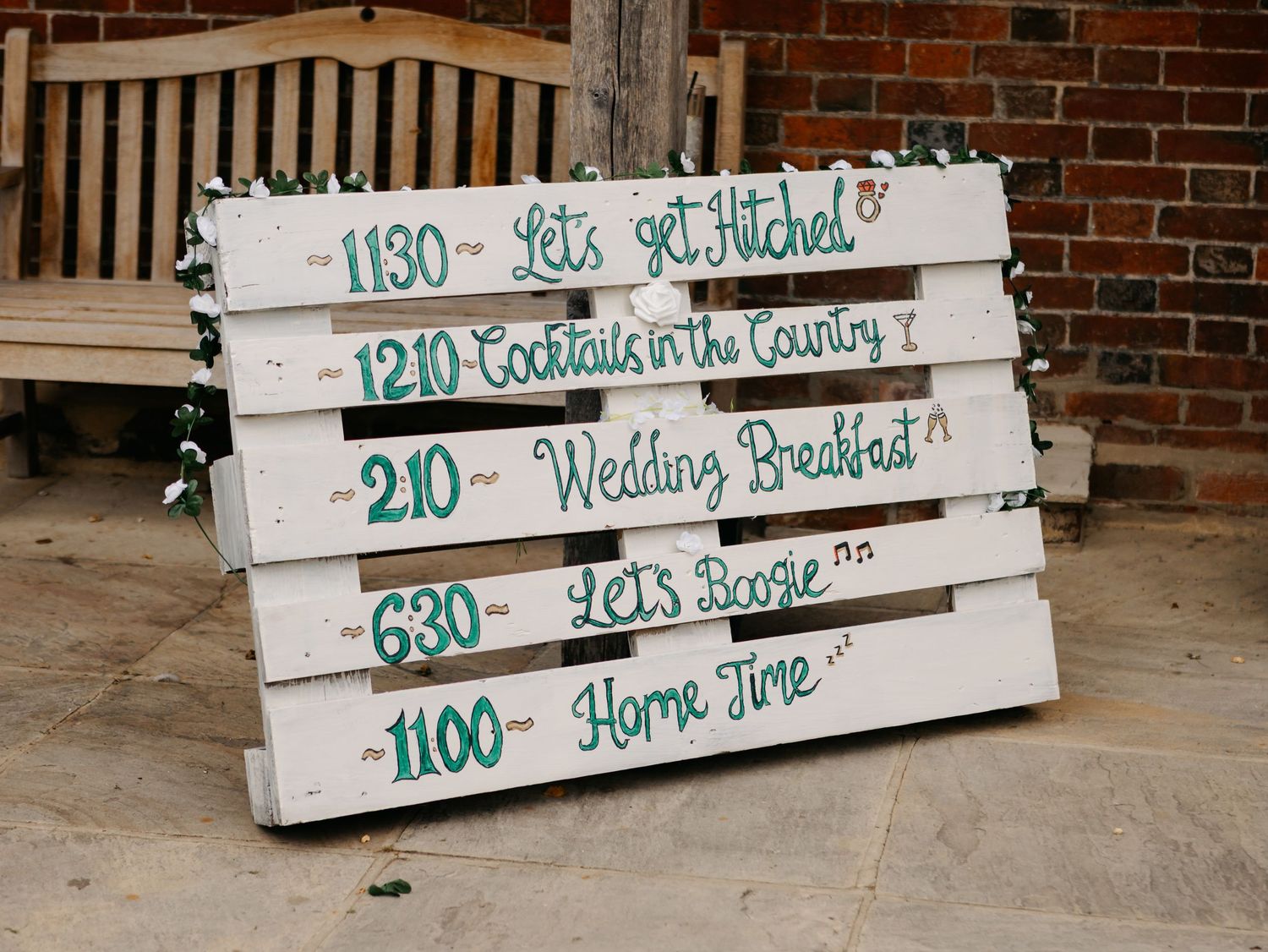 Wooden planks with handwritten schedule times and event details.