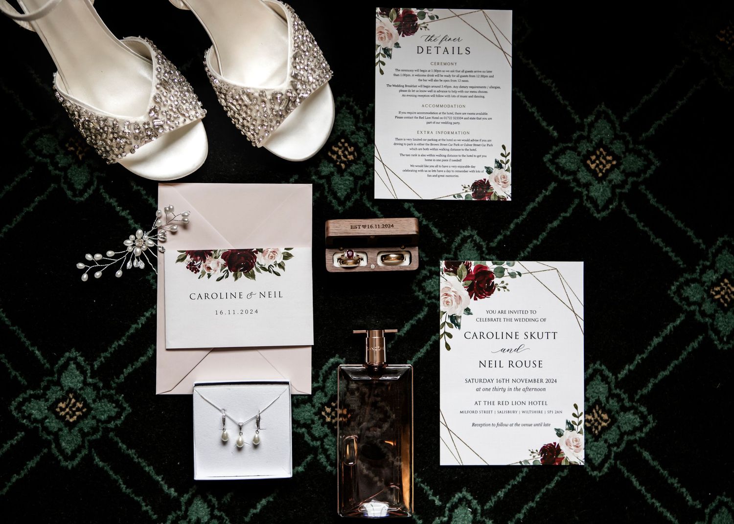 Wedding invitation suite featuring burgundy floral designs and calligraphy on white paper.