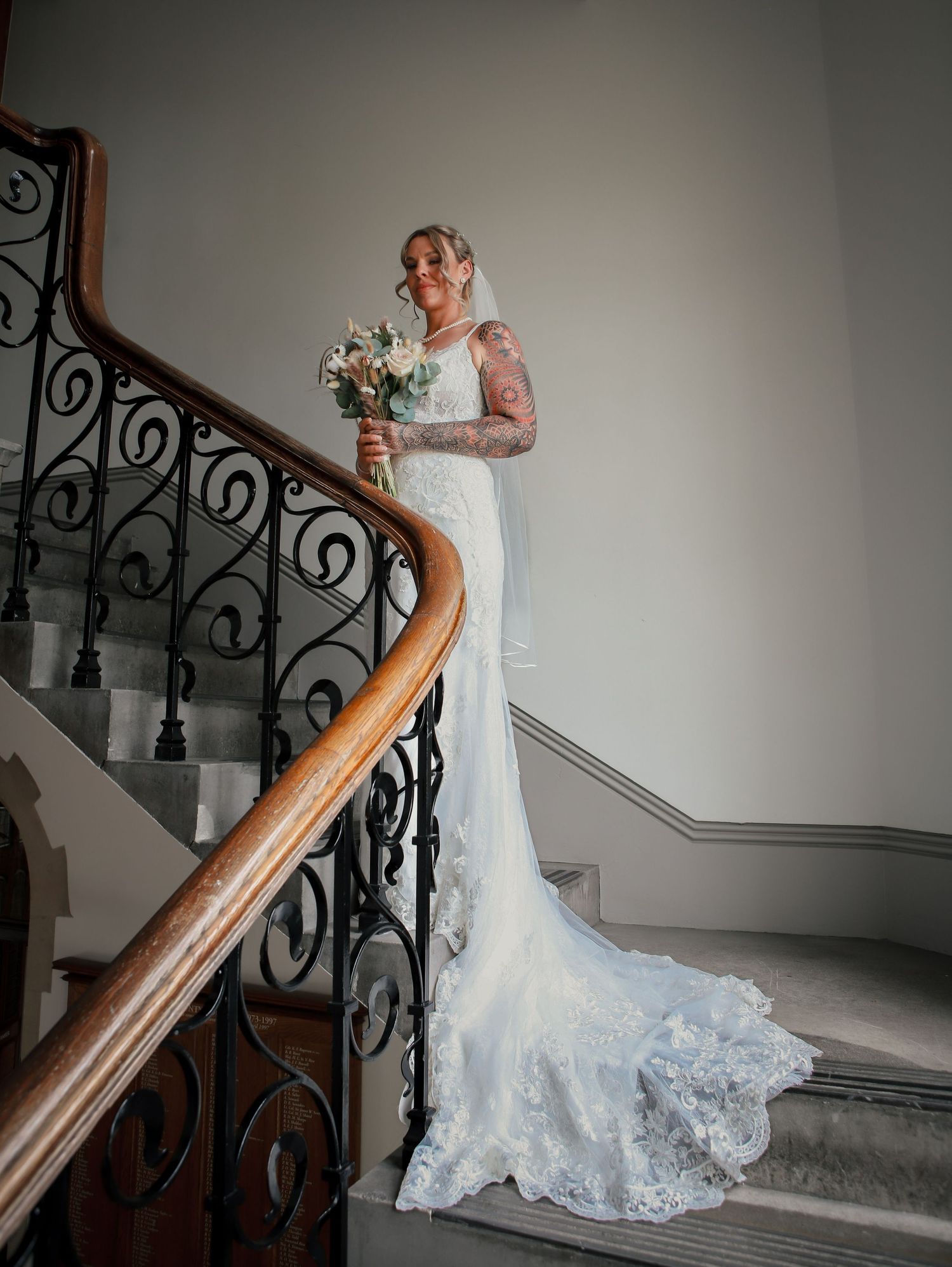 Elegant bridal portraits on vintage staircase with ornate railing.