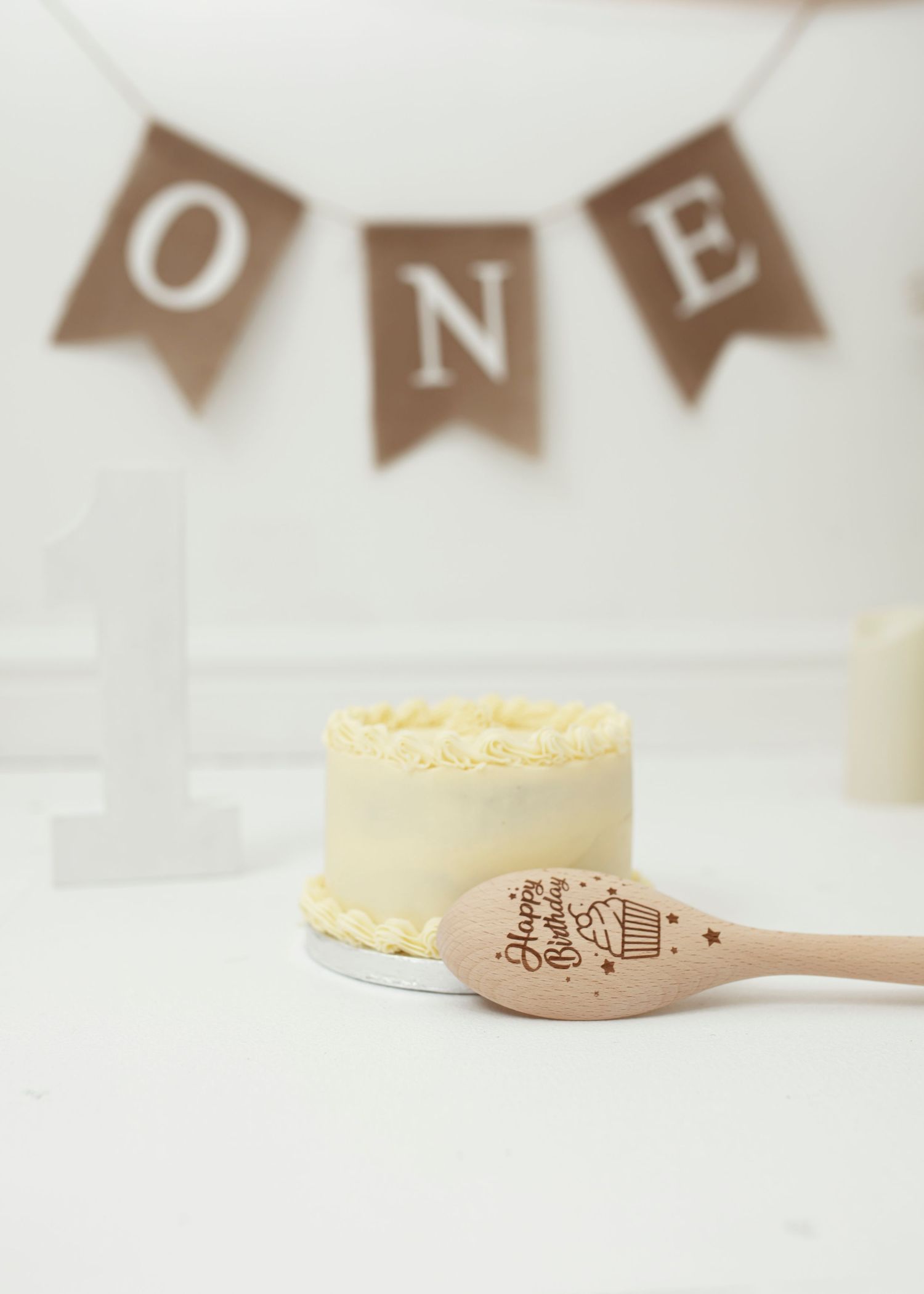 Wooden spoon and yellow cake against white background with rustic banner decor.