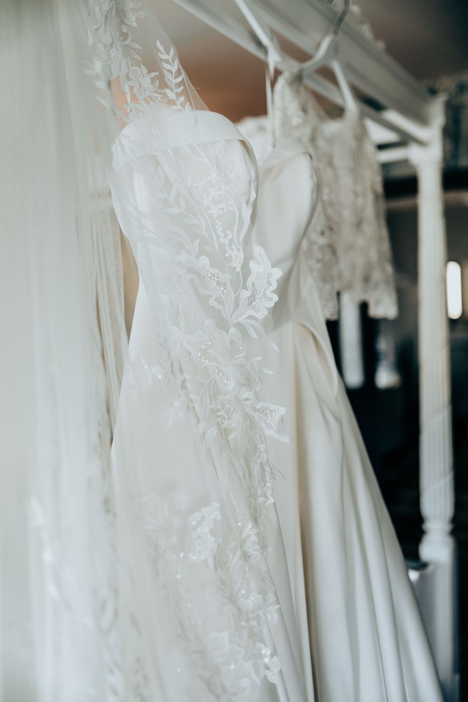 Close-up details of white wedding dresses showing intricate lace and beadwork patterns.