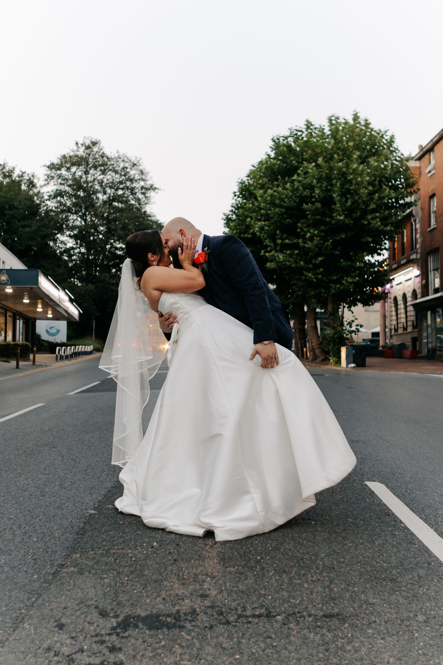 Artistic wedding photography sequence on an empty street with flowing white dress.