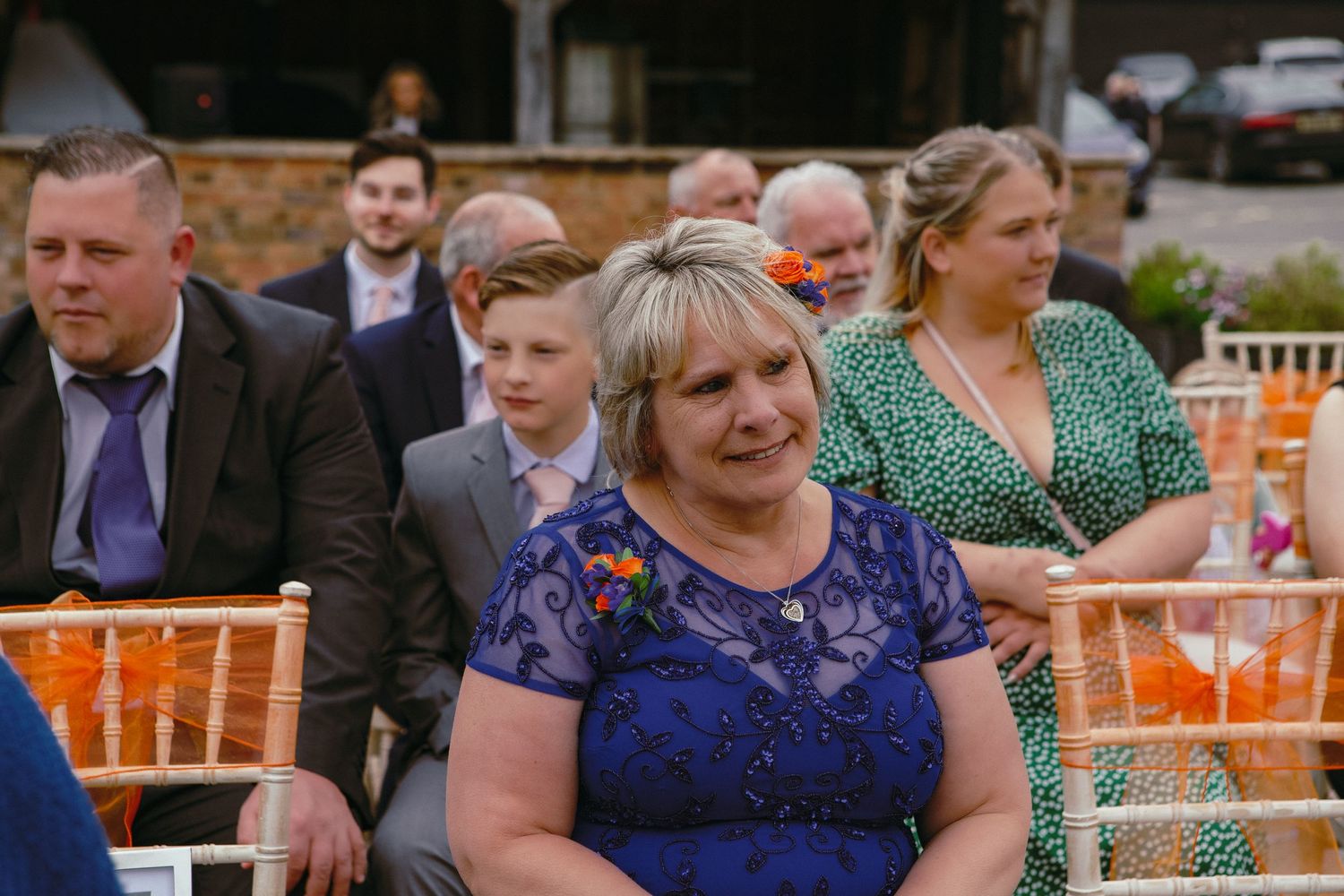 Wedding guests seated at outdoor reception venue with elegant decor.