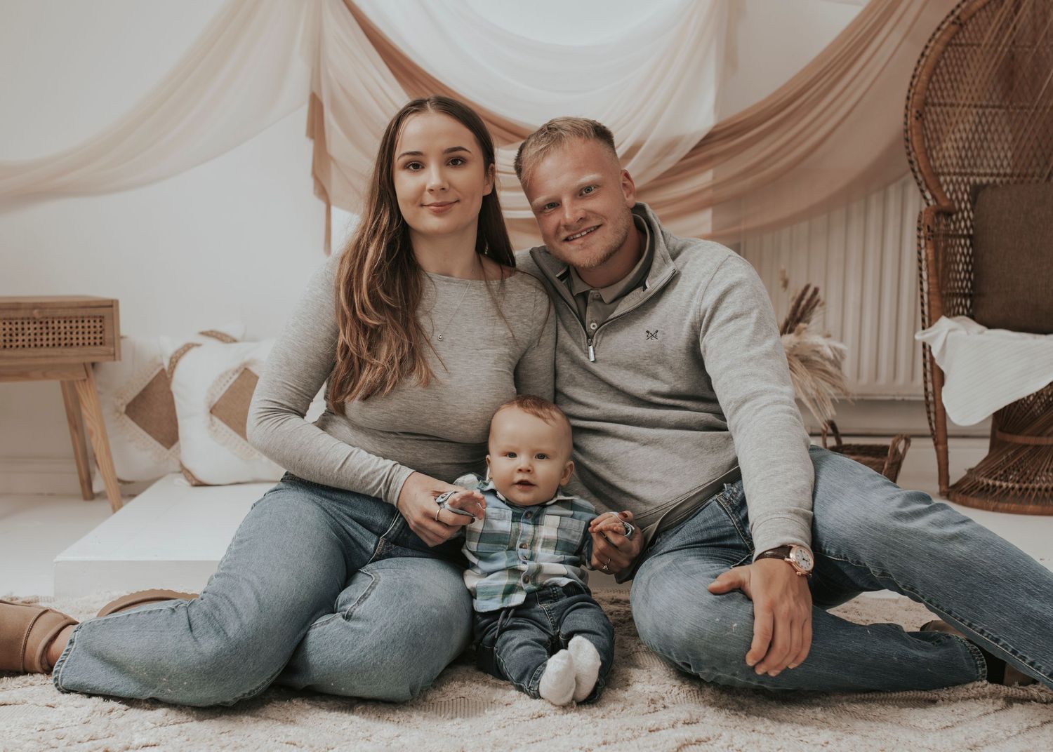 Family portrait session with casual grey outfits on white backdrop.
