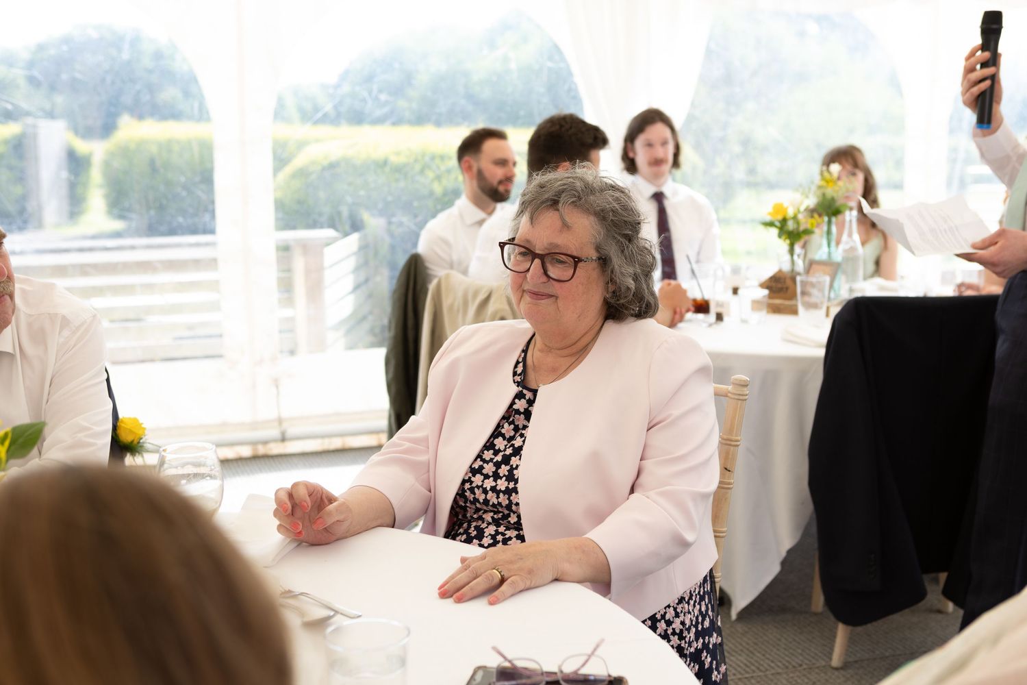 Candid reception scene with guests mingling at outdoor wedding tables.