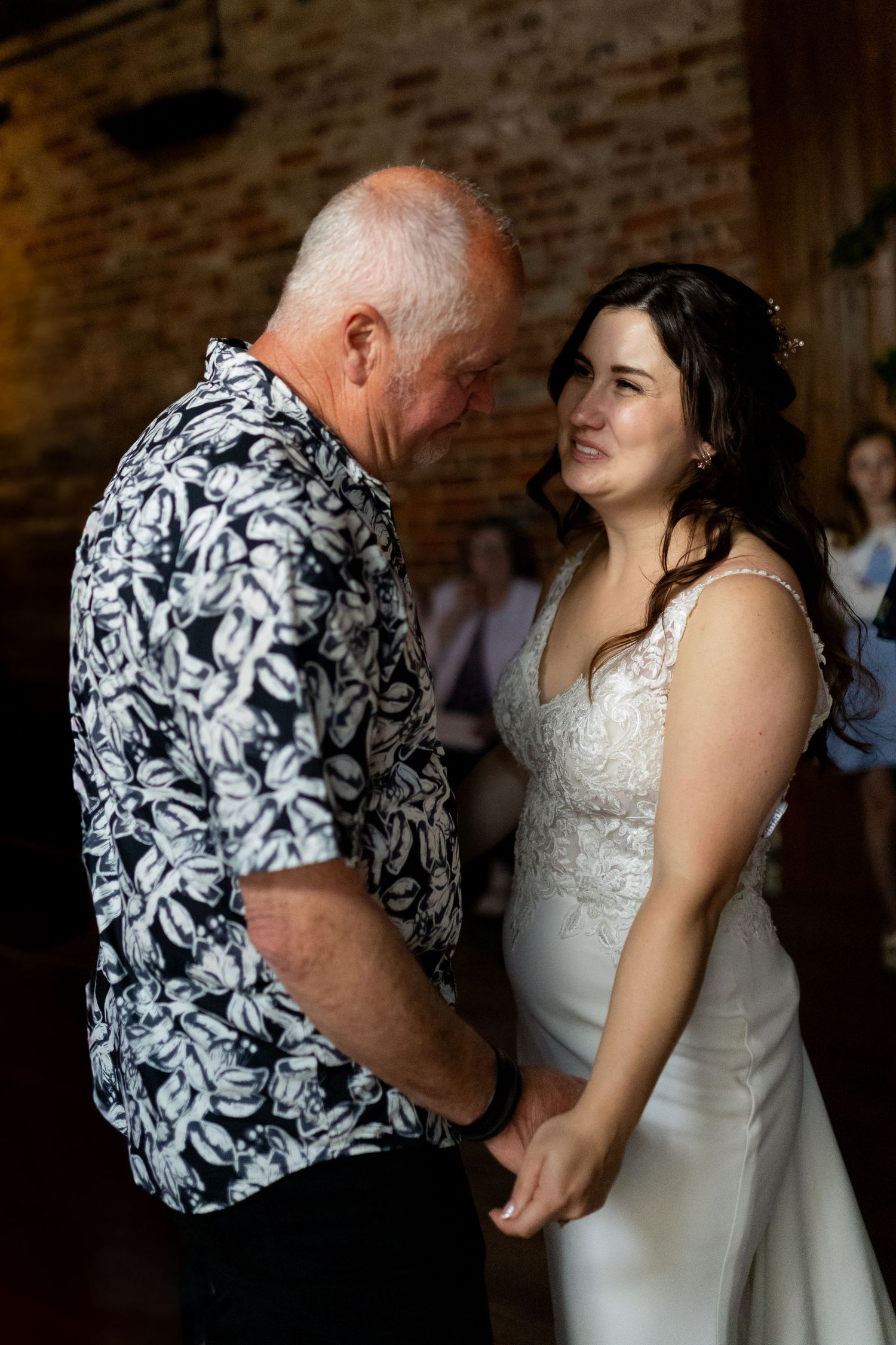 A series of candid dance moments at a wedding reception showing a black and white floral shirt.