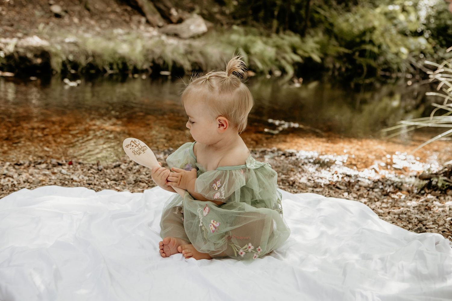 Outdoor cake smash photography session with baby in mint green outfit.