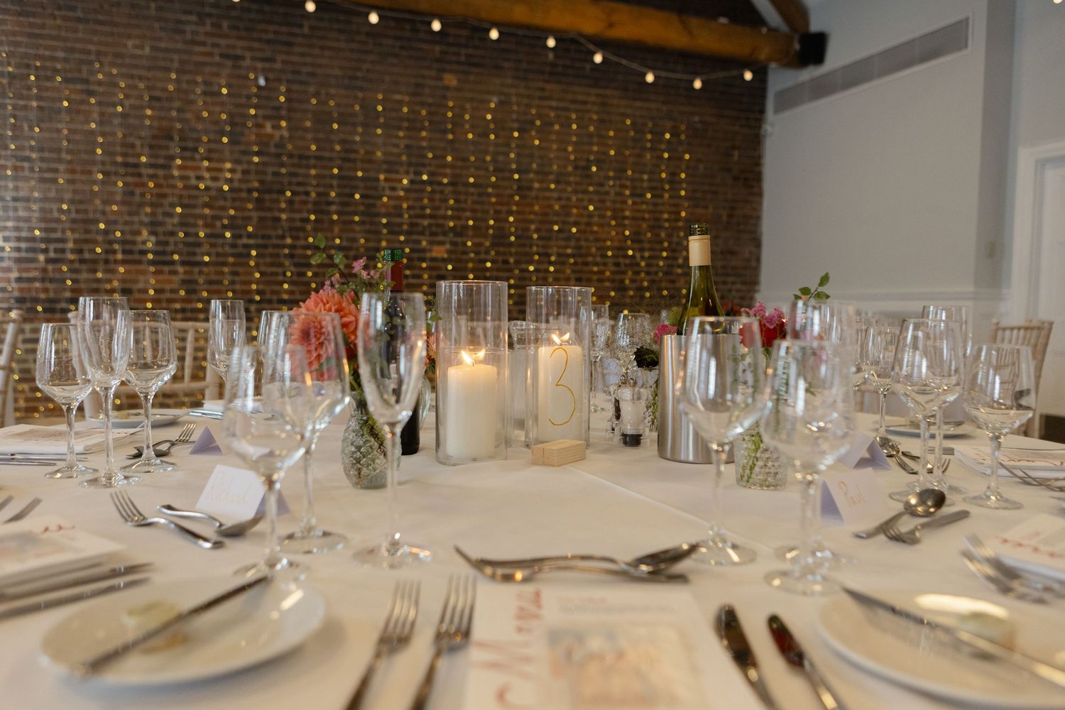 Elegant wedding reception table setting with wine glasses and place settings.
