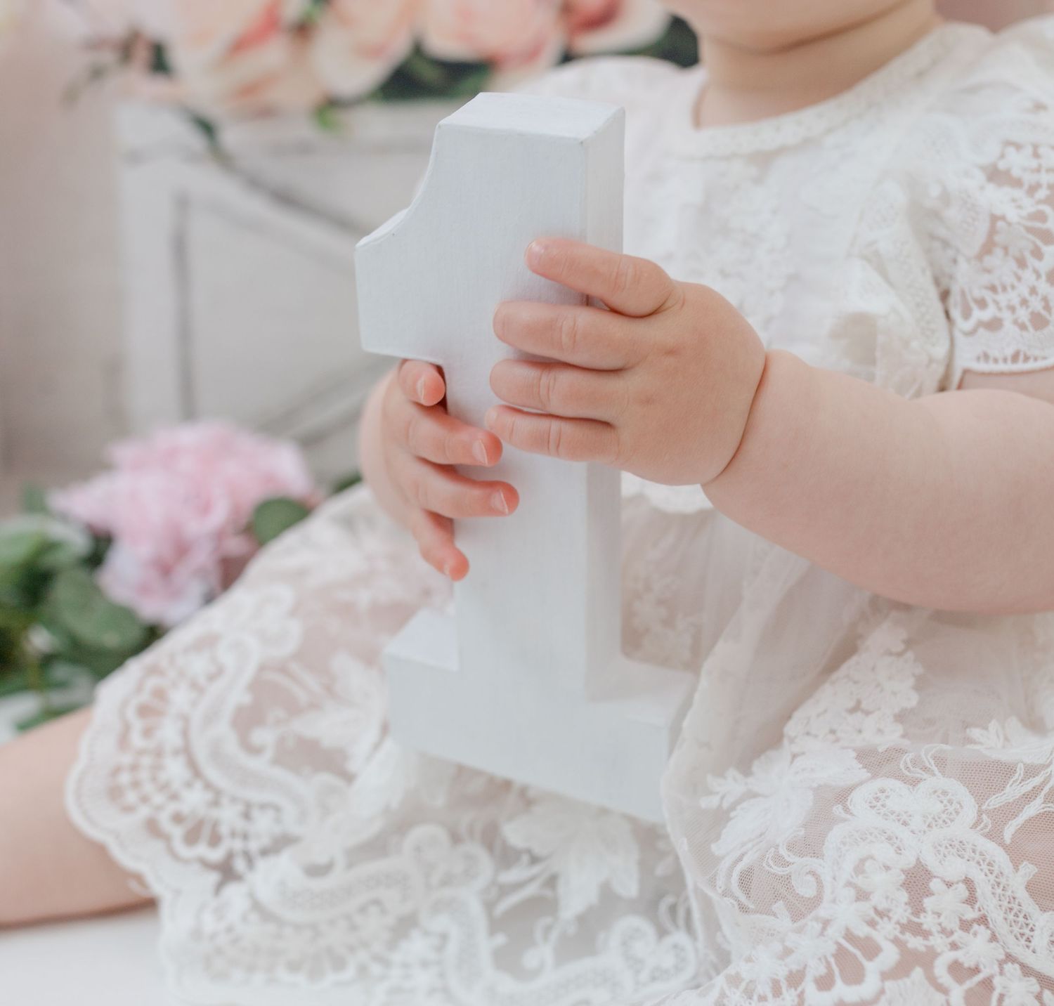 Delicate lace details and white paper in feminine styled photography setting.