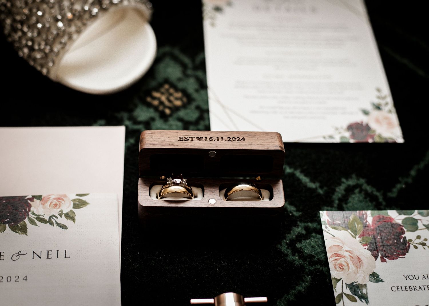Elegant wedding stationery set with floral designs and white envelopes on dark background.