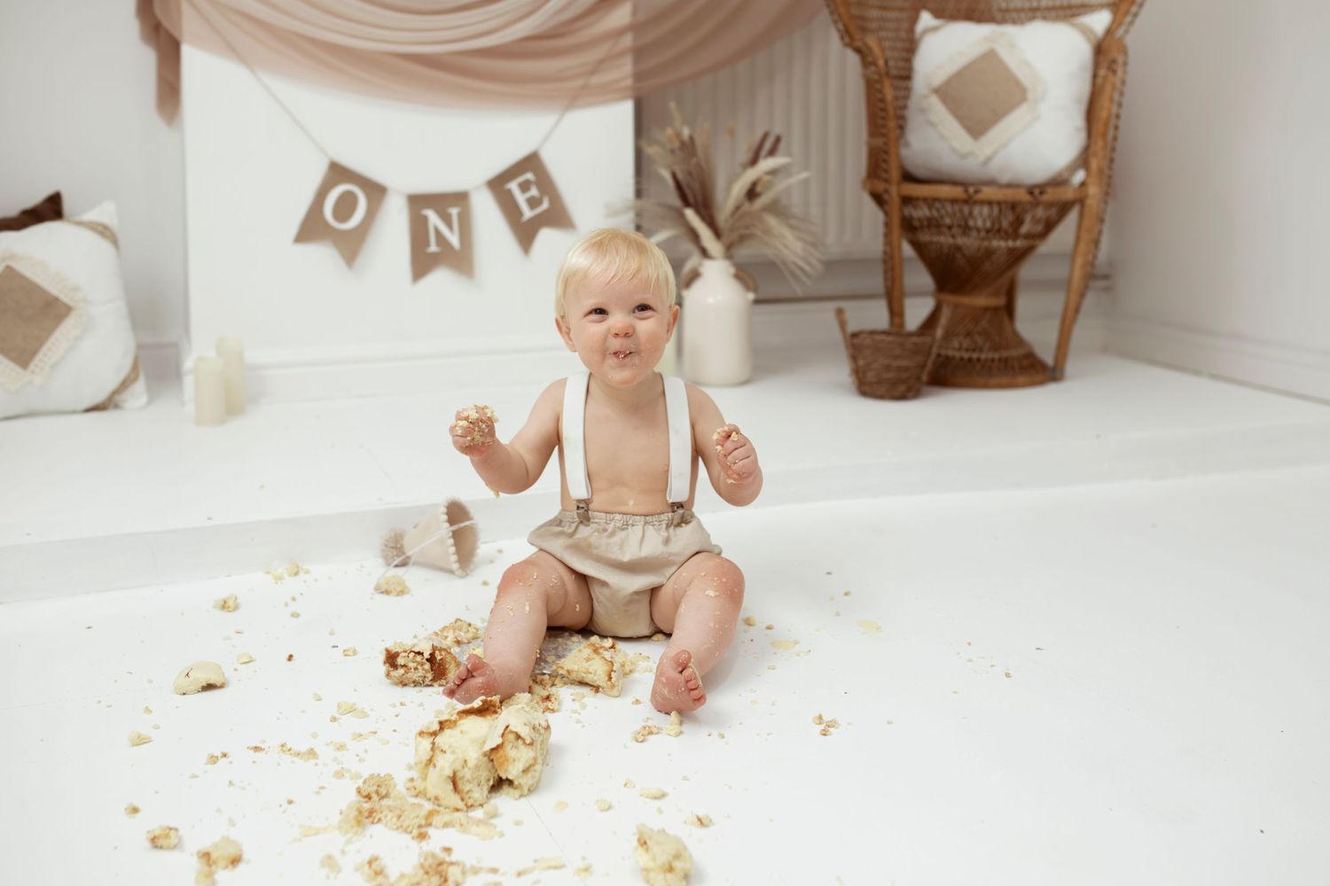 Neutral toned studio setup with vintage decorations and banners for baby photography session.