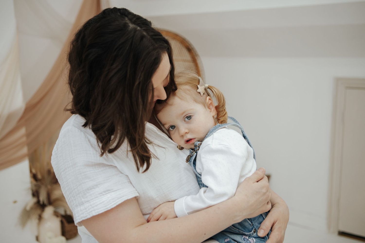 A tender moment captured between people in matching white and denim outfits.