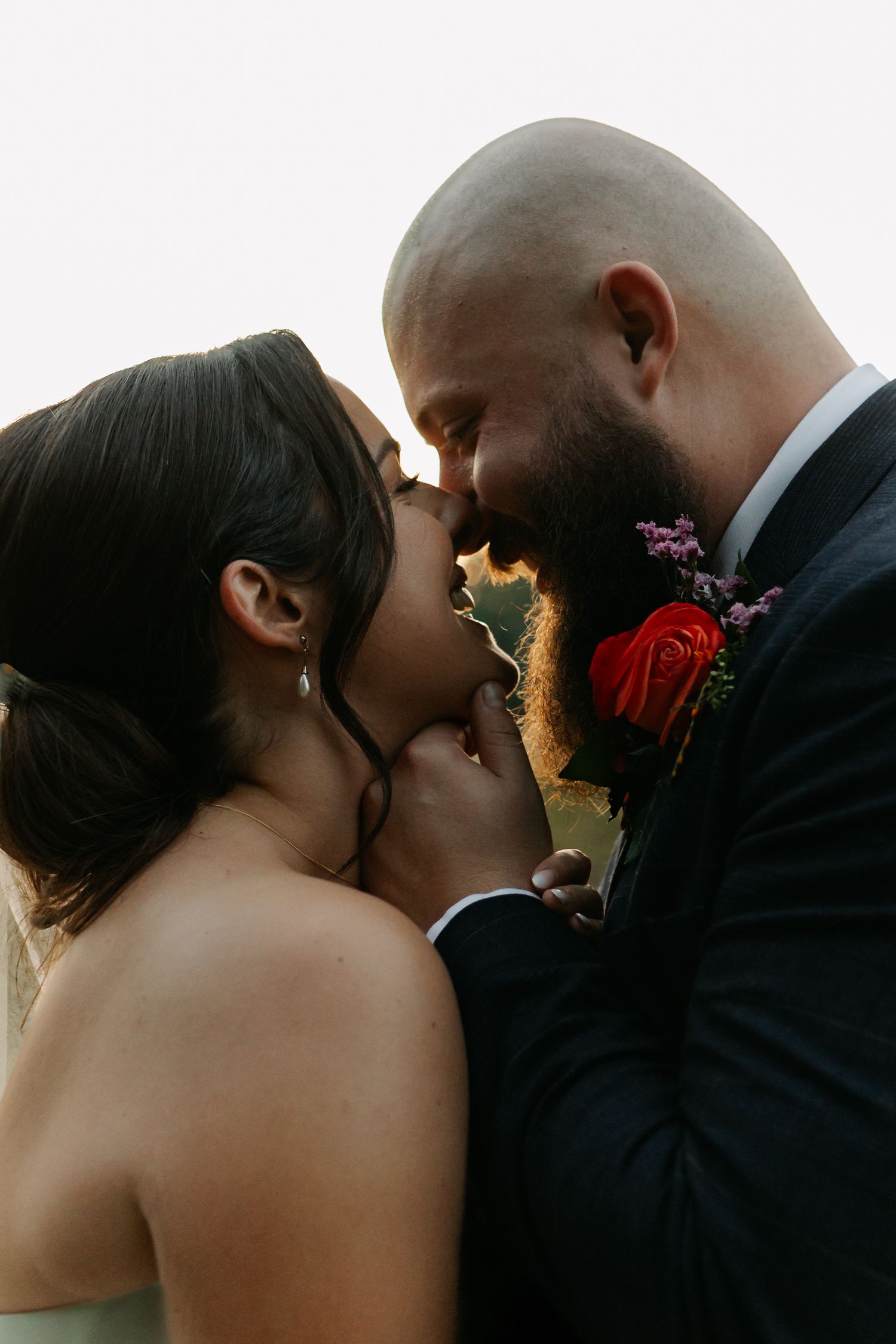 Silhouetted wedding couple sharing an intimate moment at sunset.