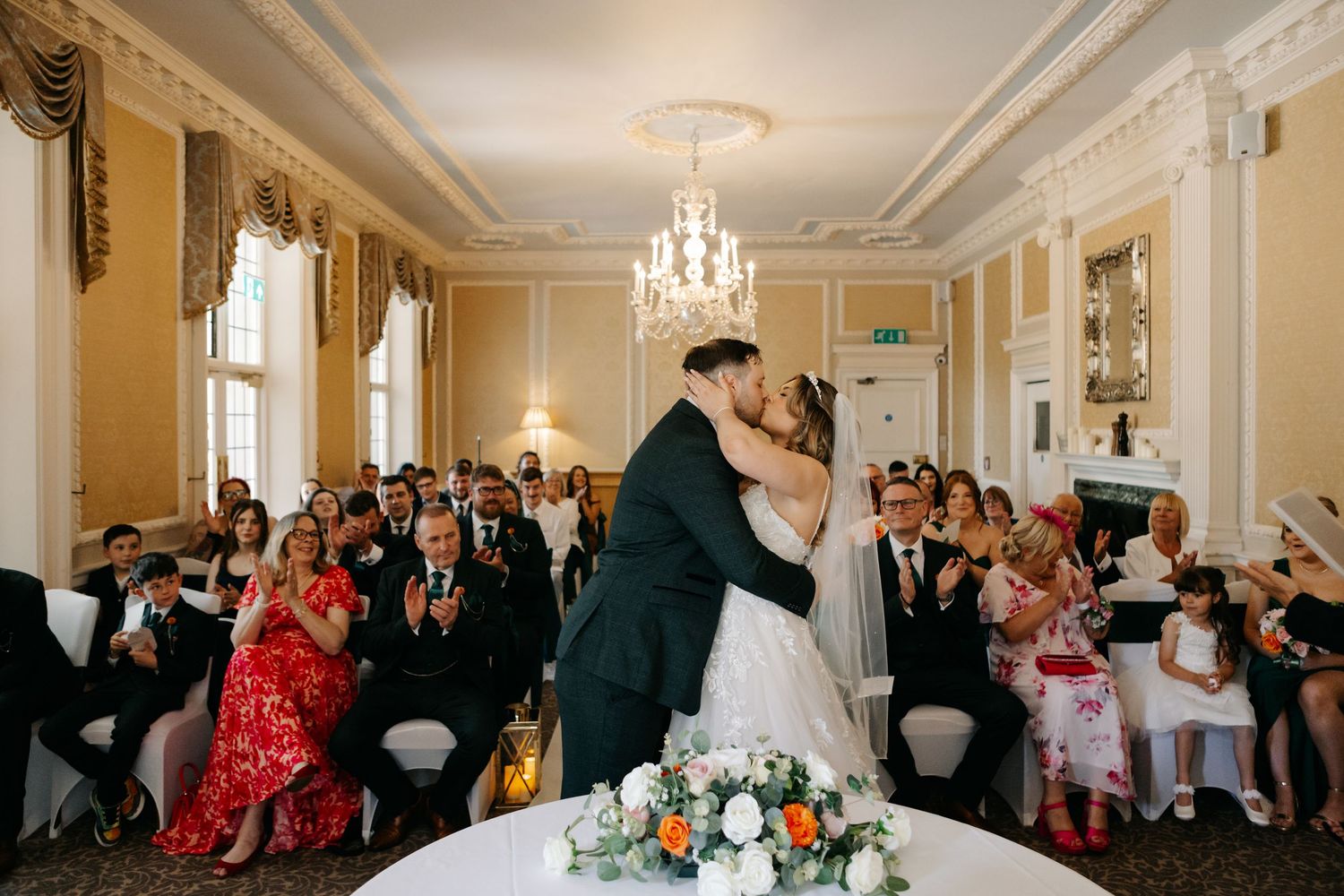 Elegant wedding reception hall with chandeliers and cream colored walls.
