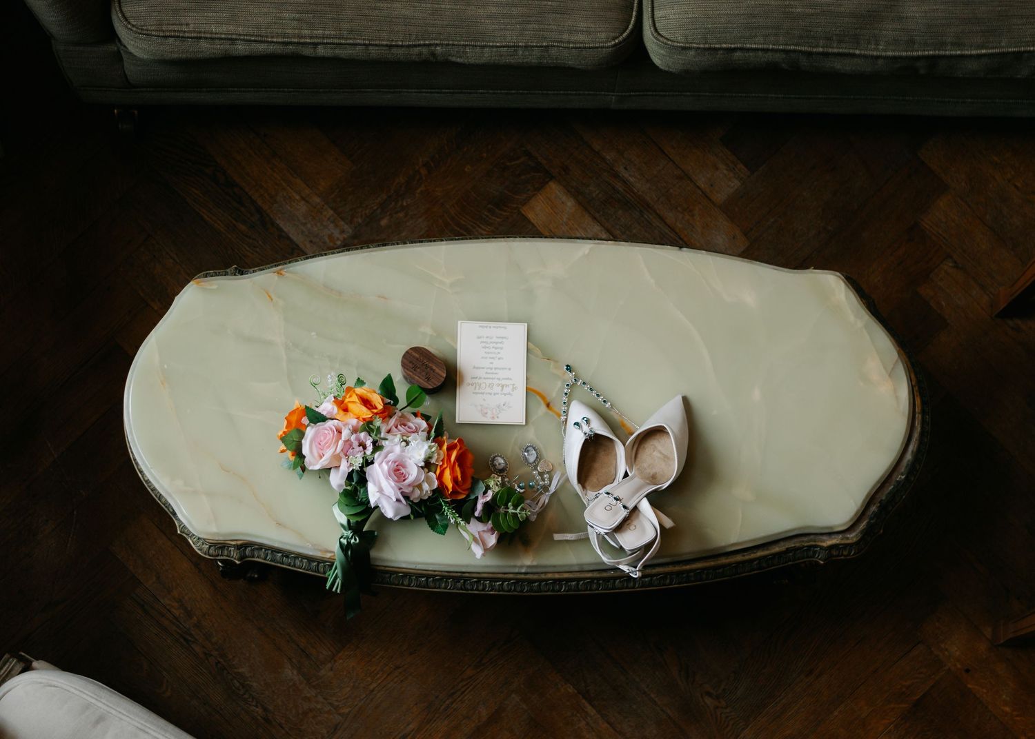 Wedding accessories including a veil and floral arrangements laid out on grey couch cushions.
