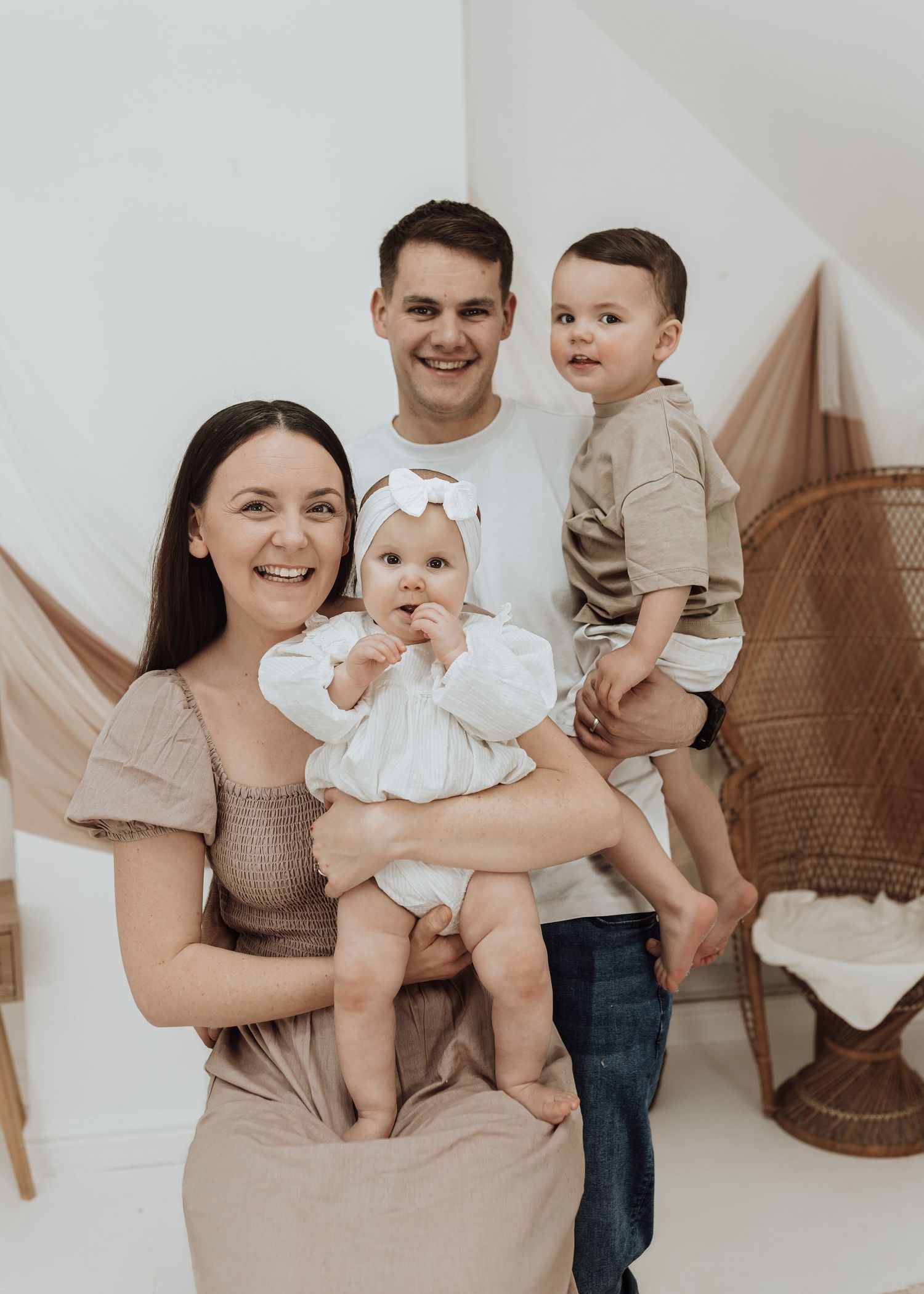 Studio family photography session featuring natural interactions and neutral color palette.