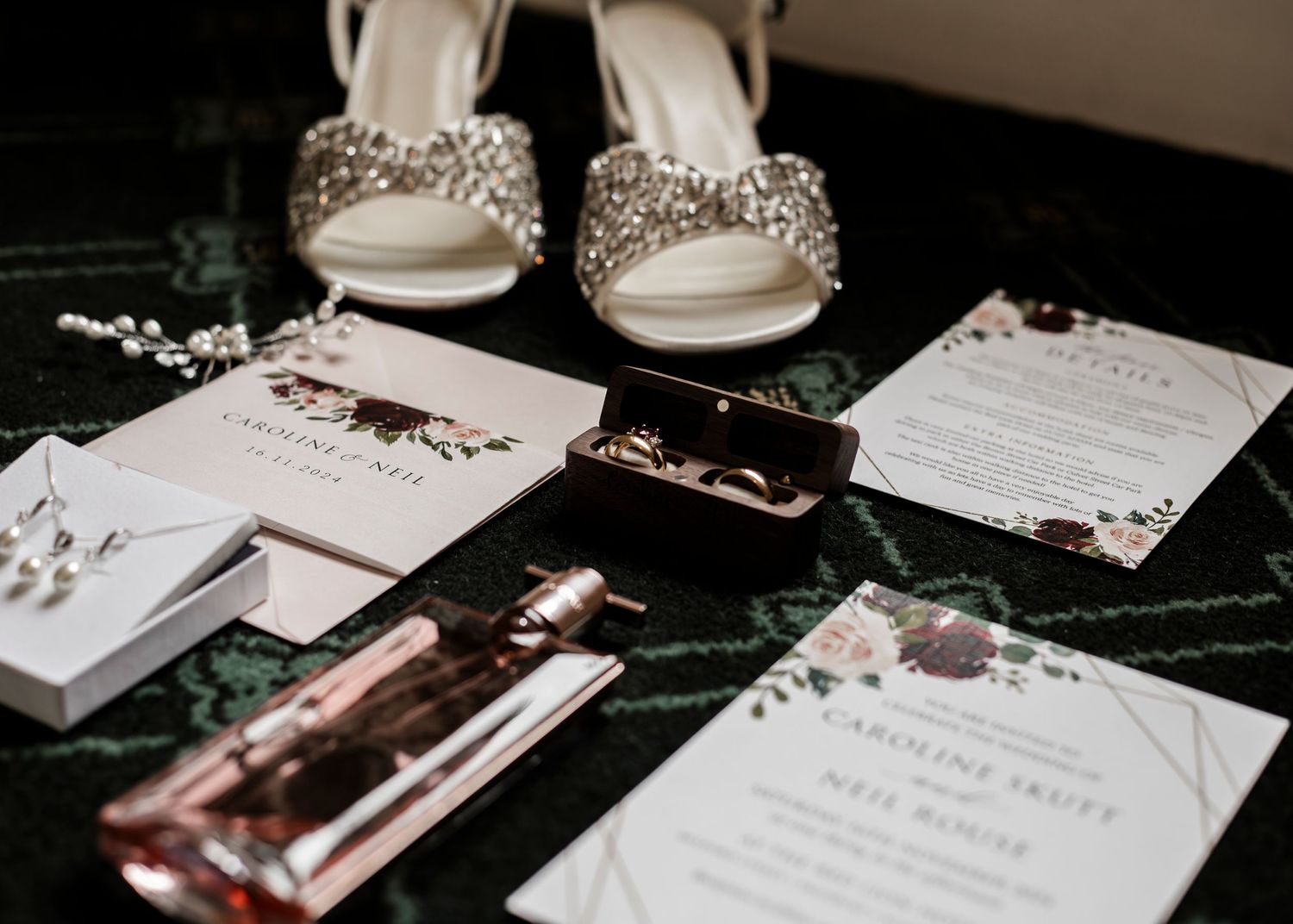 Wedding stationery and invitation suite arranged on dark surface with elegant details.