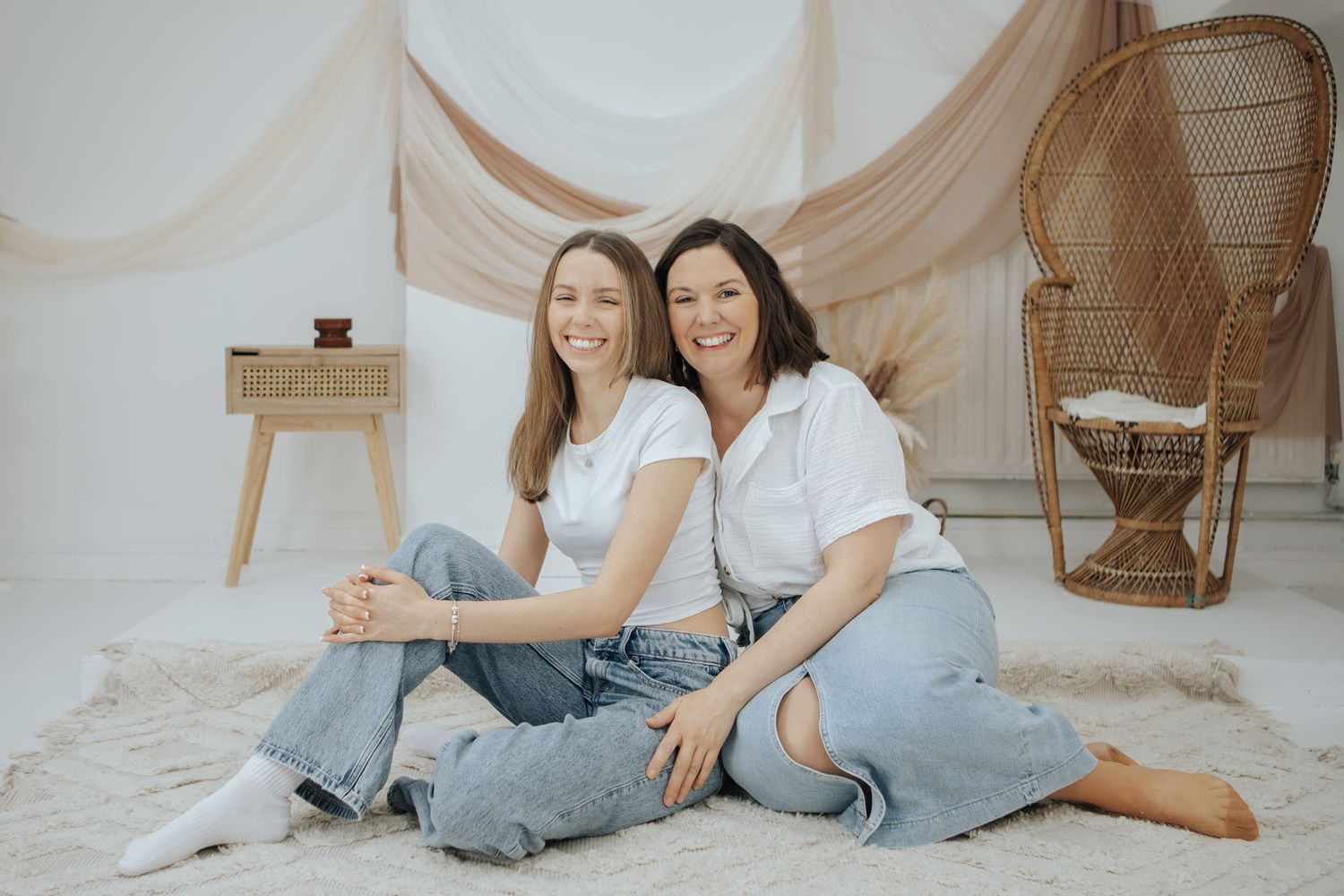 Candid family photo shoot with everyone wearing coordinated white tops and jeans.
