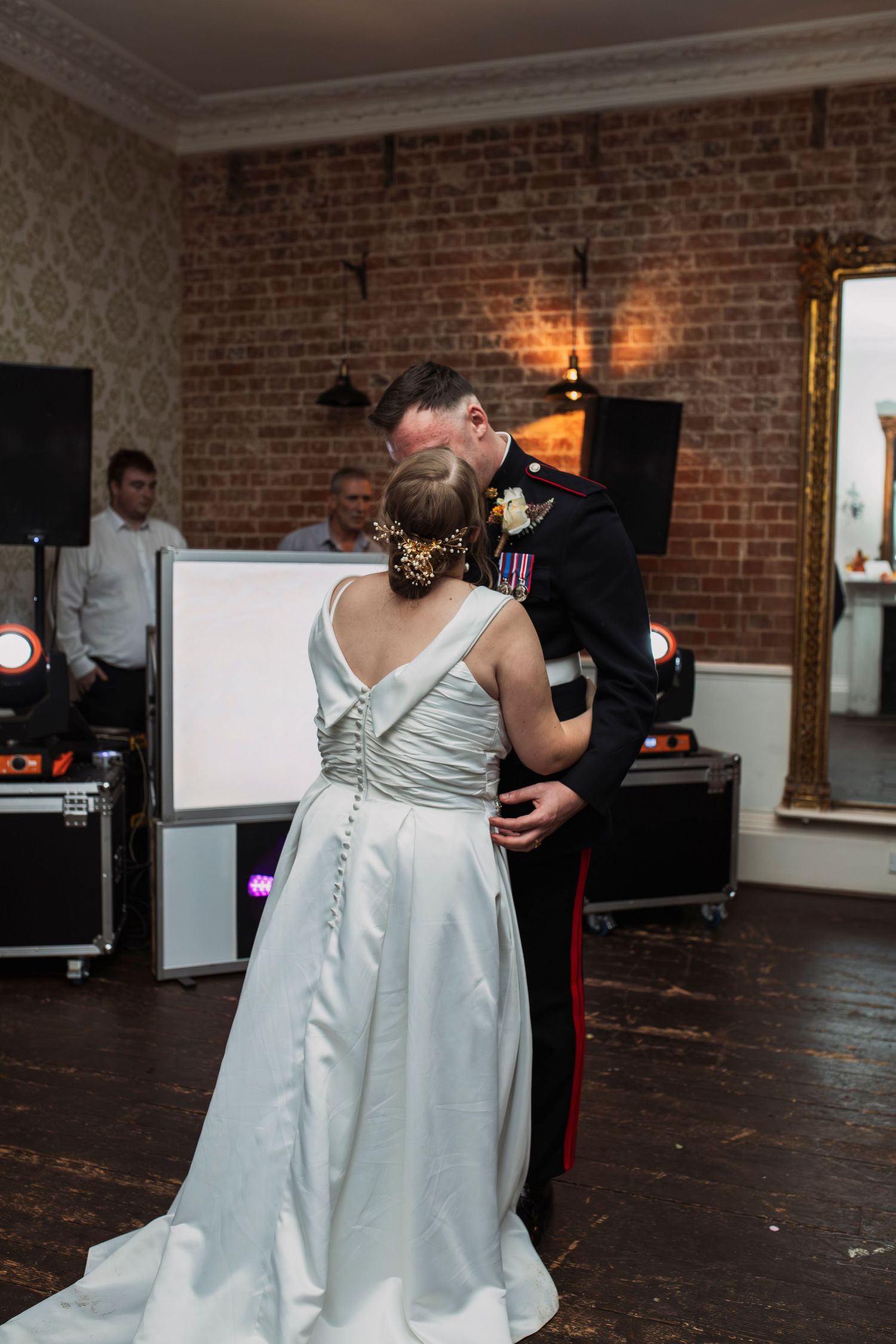 Elegant ballroom wedding venue with exposed brick walls and hardwood floors.