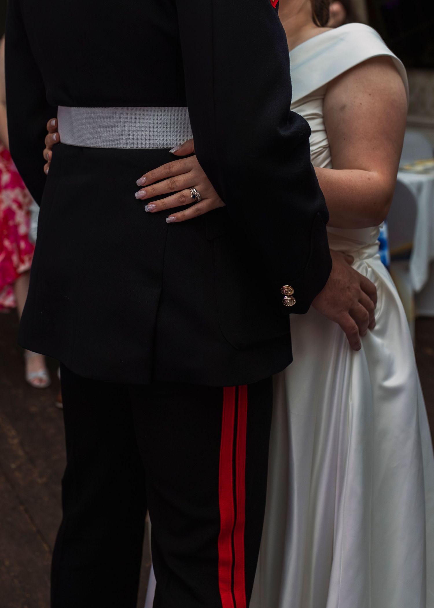 Military formal wear and white wedding dress details shown in close-up during ceremony.