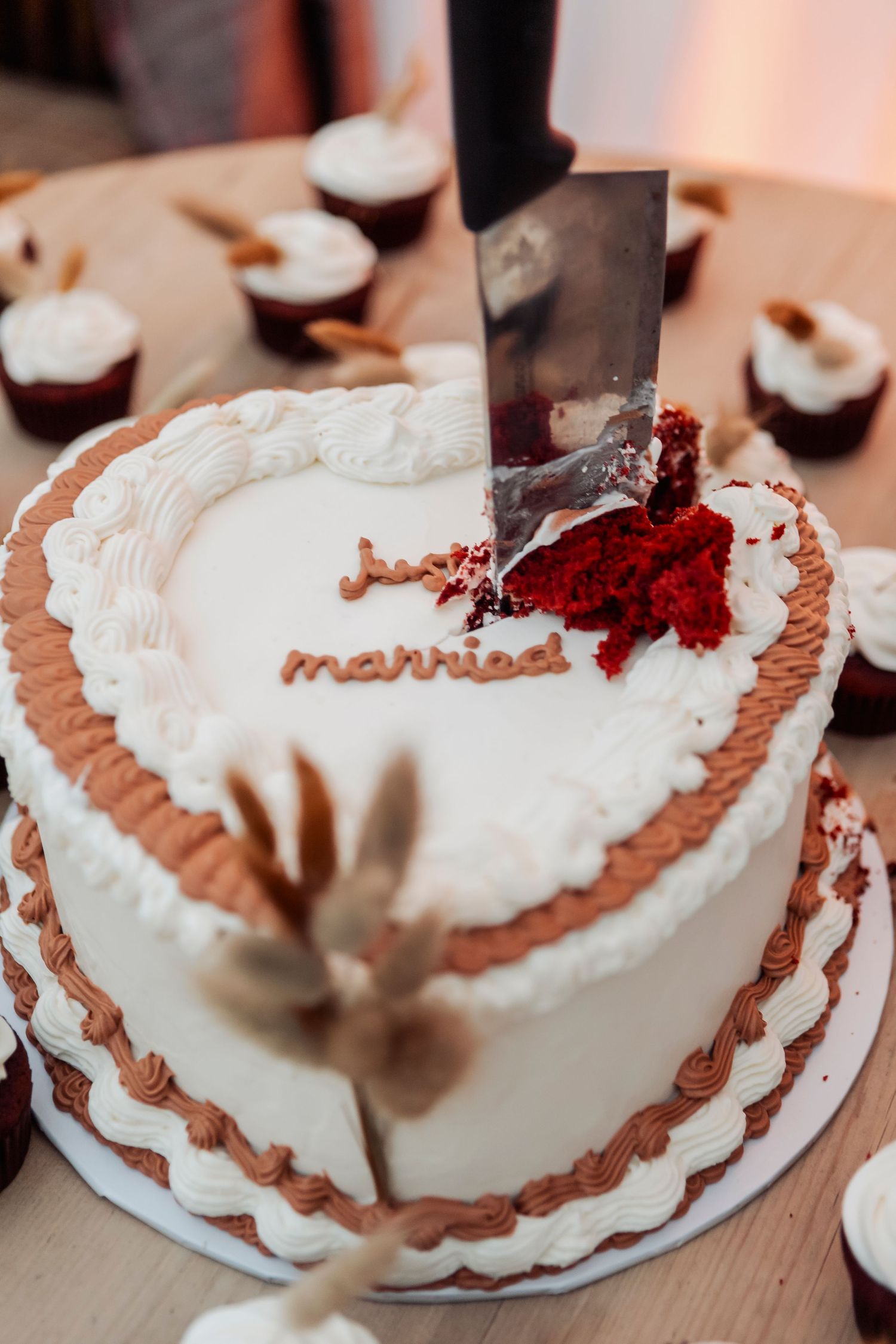 Sequence of cutting into a white wedding cake with brown decorative piping.