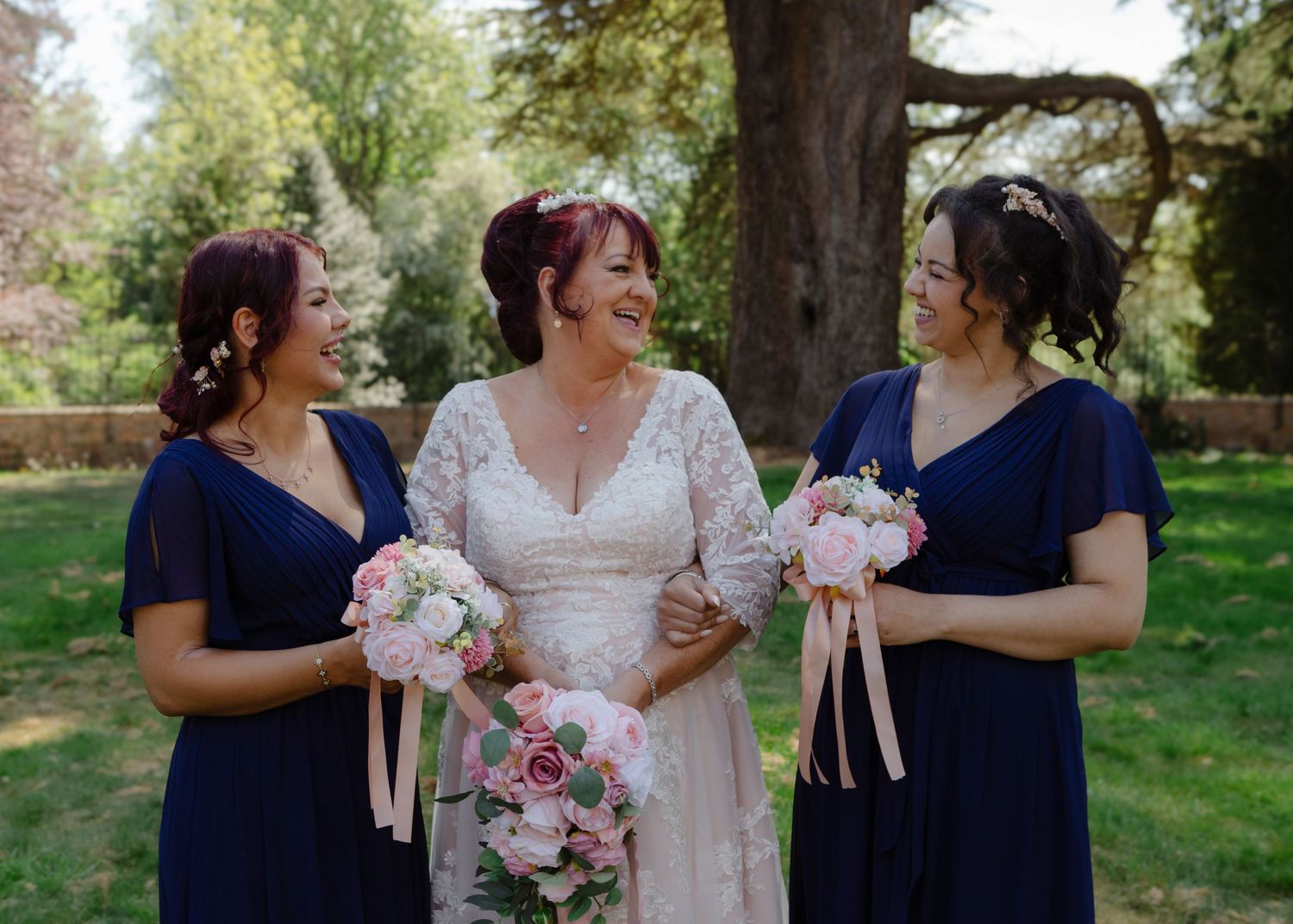 Wedding party in navy blue and white dresses posing together outdoors.