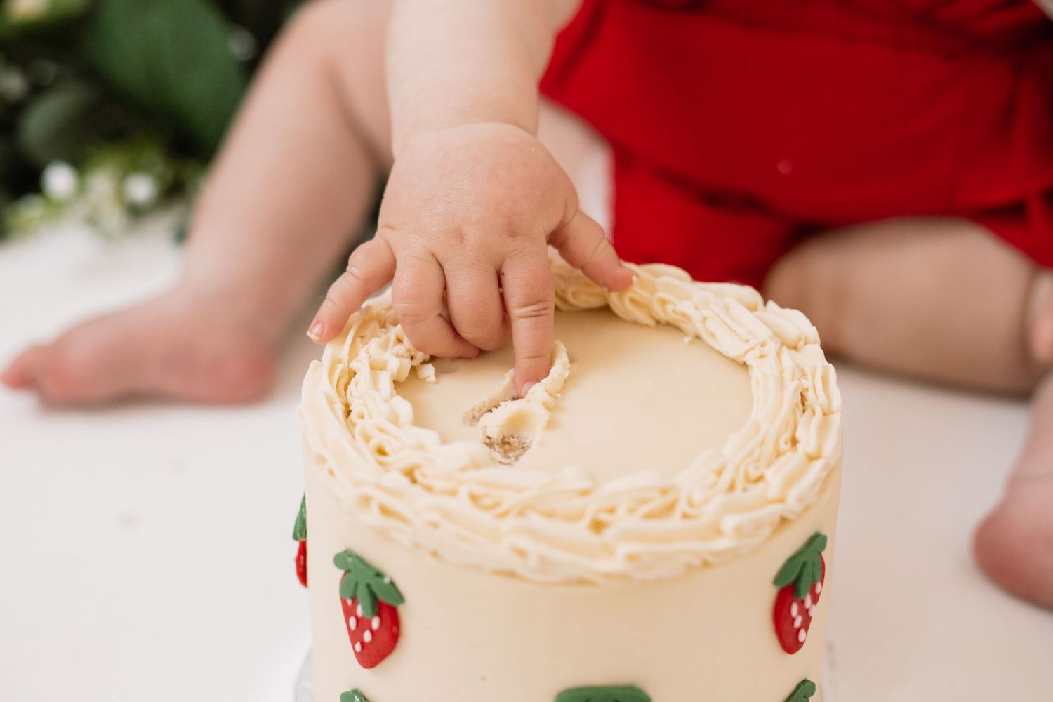 Close-up of strawberry decorated cake with cream frosting.
