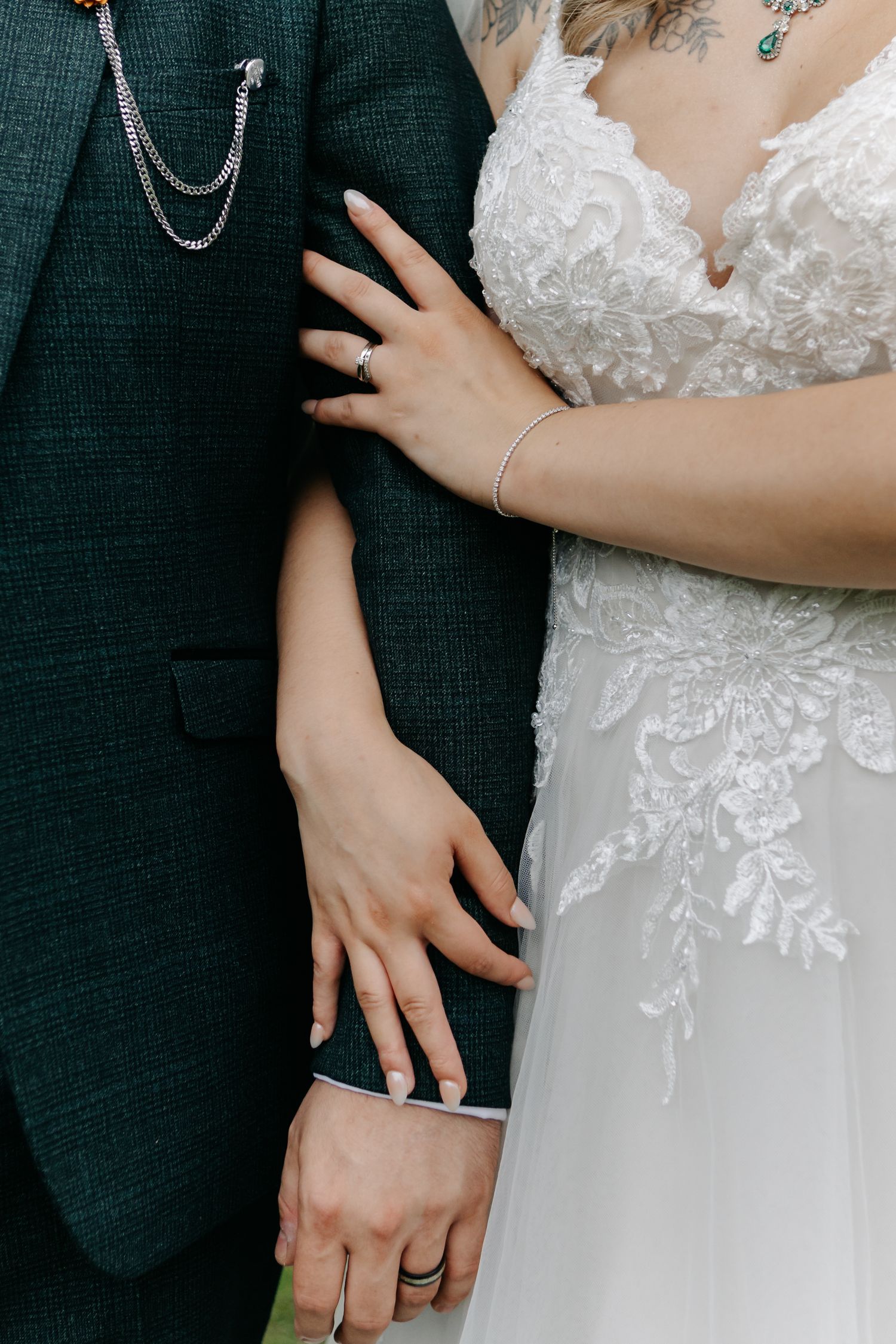 Detail shots of wedding attire showing white lace dress and dark suit.