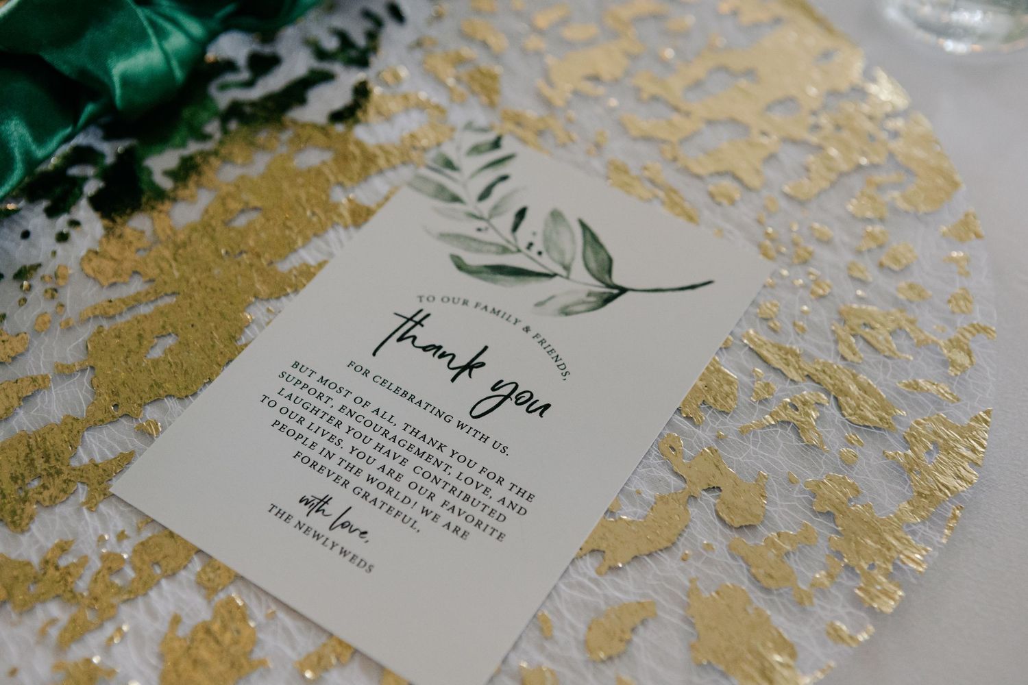 Wedding stationery with gold foil details and greenery accents.