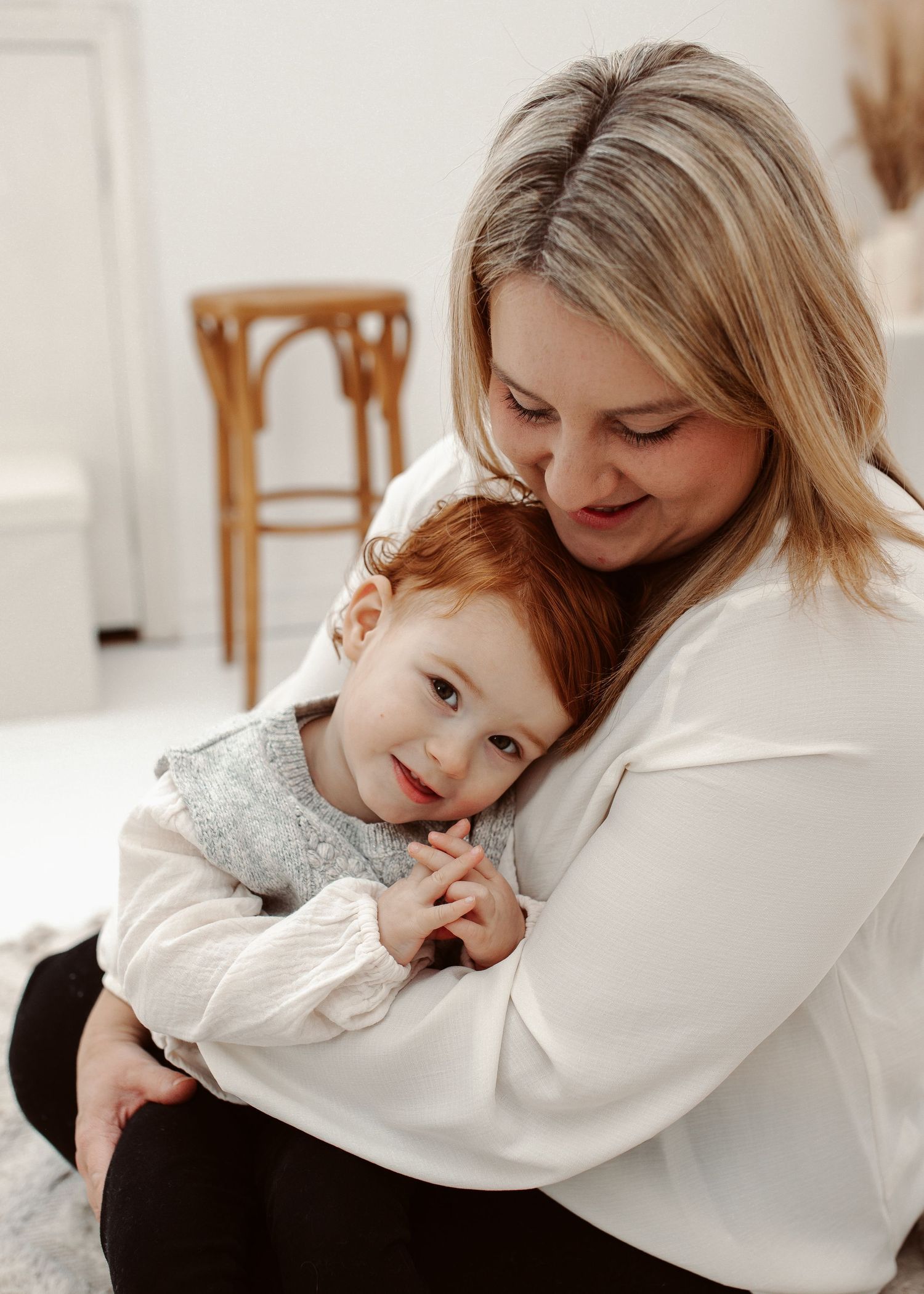 Intimate lifestyle portrait session with soft white styling and natural expressions.