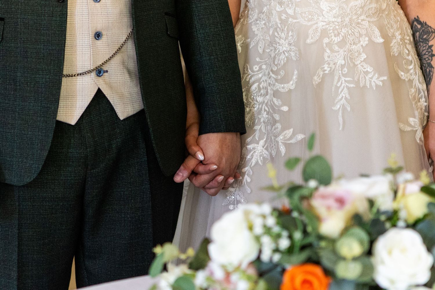 A couple sharing an intimate moment during their wedding ceremony in an elegant venue with white decor.