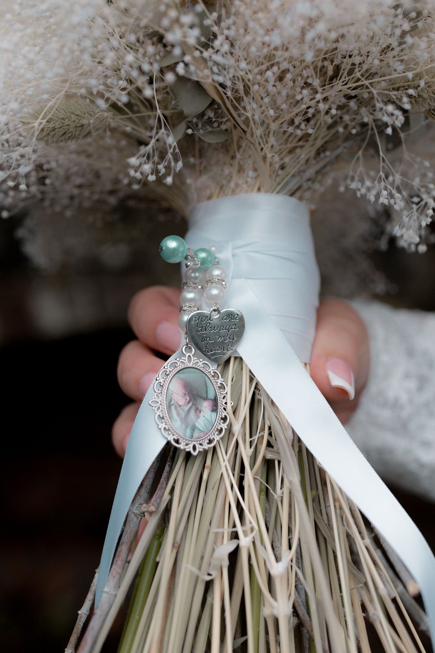Close-up of delicate white floral bouquet details with decorative ribbon and silver accents.