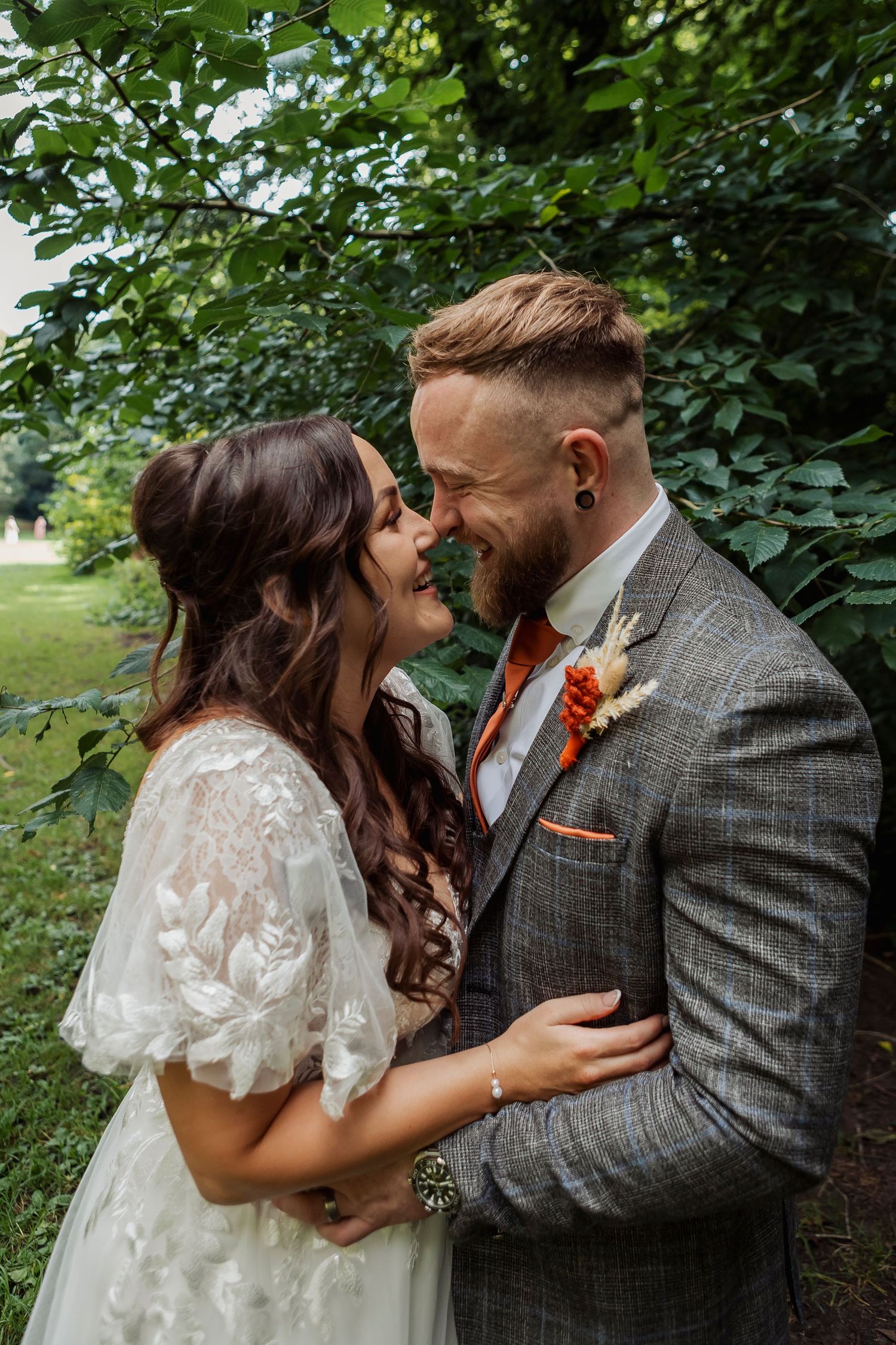 Romantic wedding portraits captured in a lush green garden setting with natural lighting.