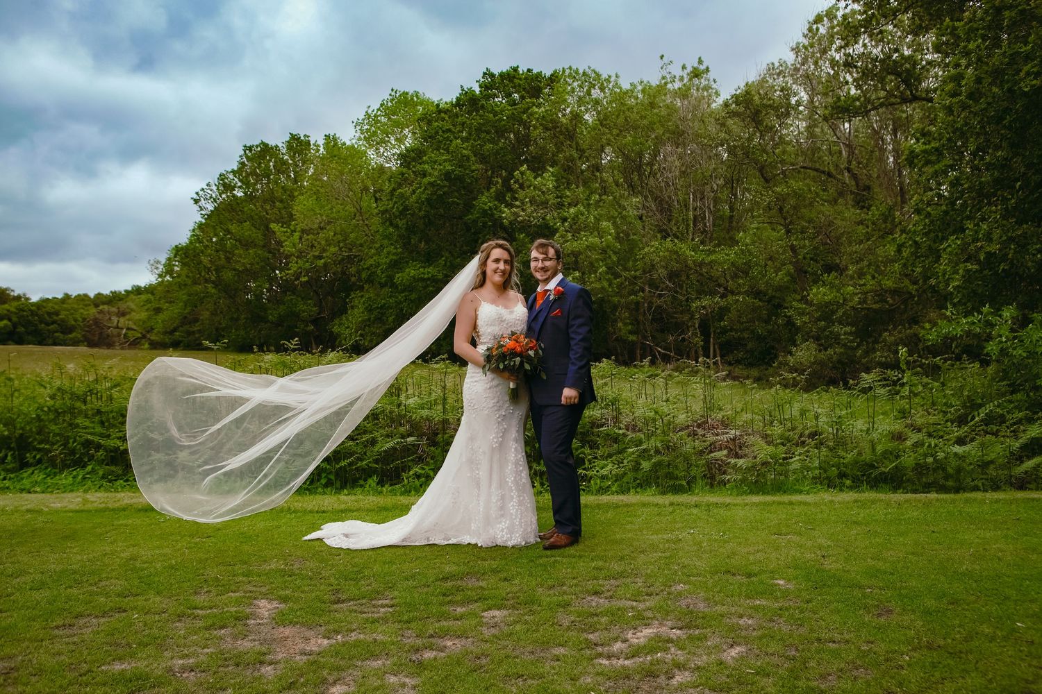 Panoramic view of wedding couple posing in scenic natural landscape.